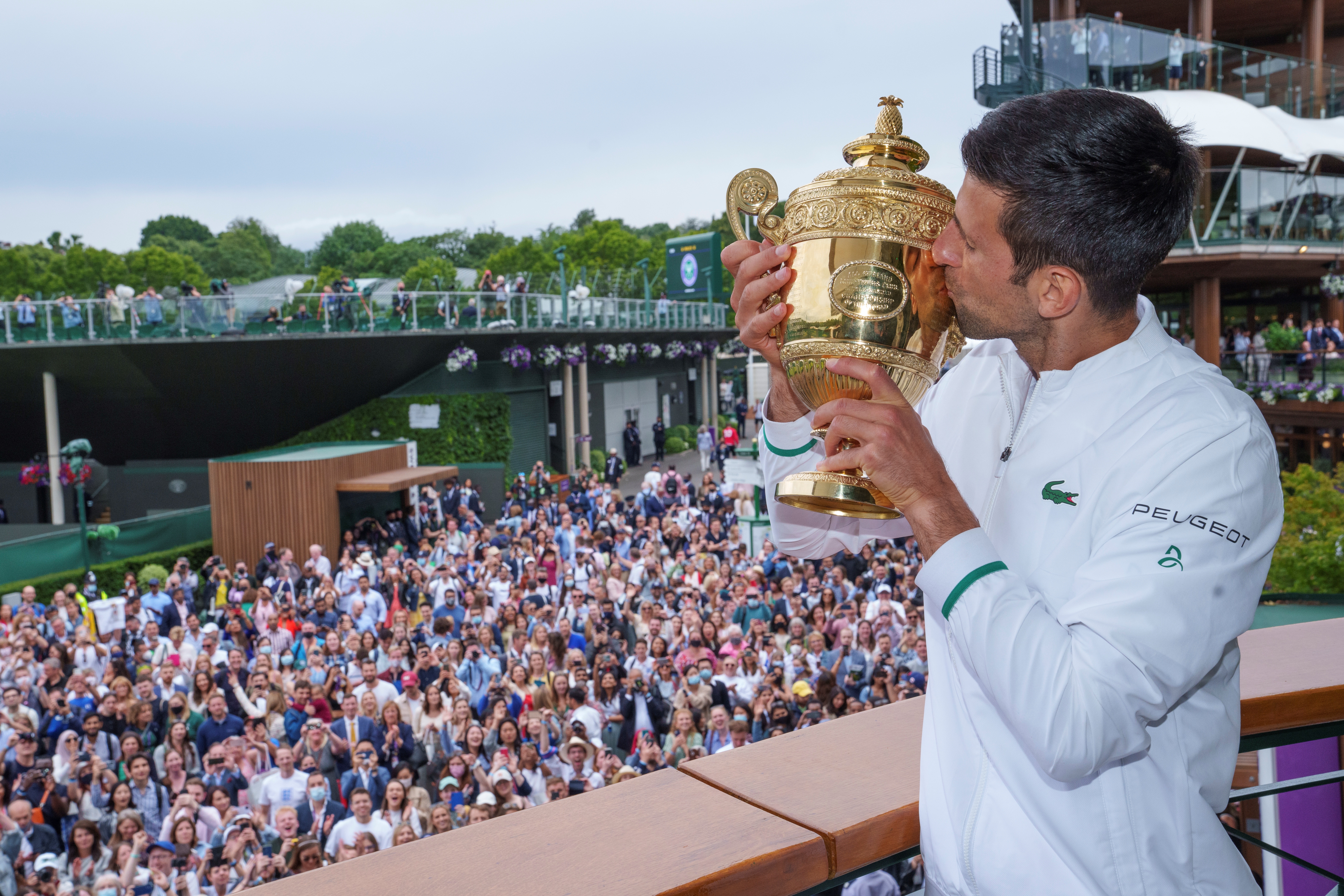 Wimbledon (United Kingdom), 11/07/2021.- Spectators watching on as Novak Djokovic of Serbia poses with the Gentlemen's Singles Trophy on the balcony of the Clubhouse after winning the Gentlemen's Singles at The Wimbledon Championships tennis tournament in Wimbledon, Britain, 11 July 2021. (Tenis, Reino Unido) EFE/EPA/AELTC / Bob Martin / POOL EDITORIAL USE ONLY