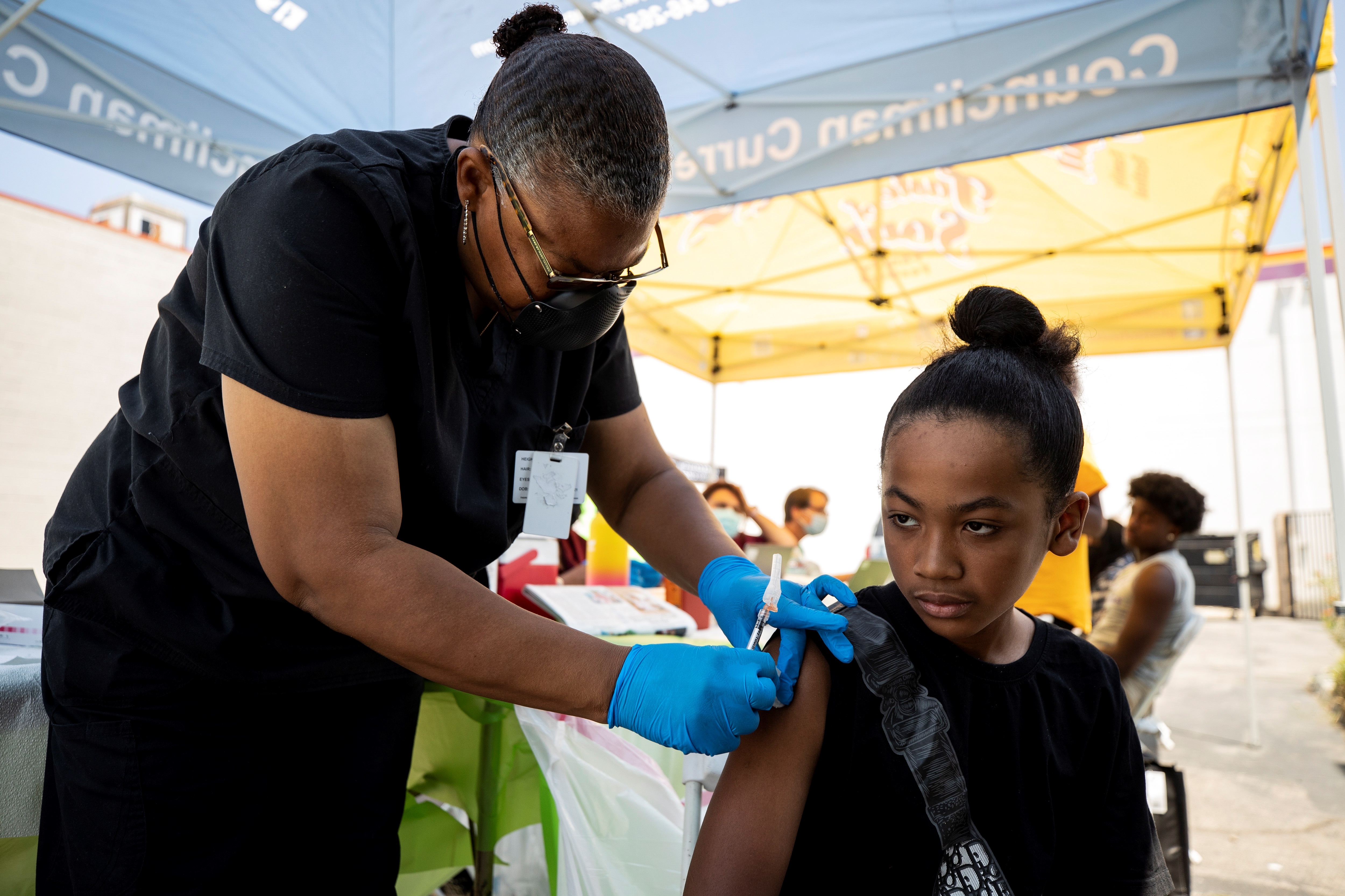 Joven de 12 años recibe vacuna contra el coronavirus en un puesto móvil en Crenshaw, en el Sur de Los Ángeles, California. (Foto Prensa Libre: EFE)