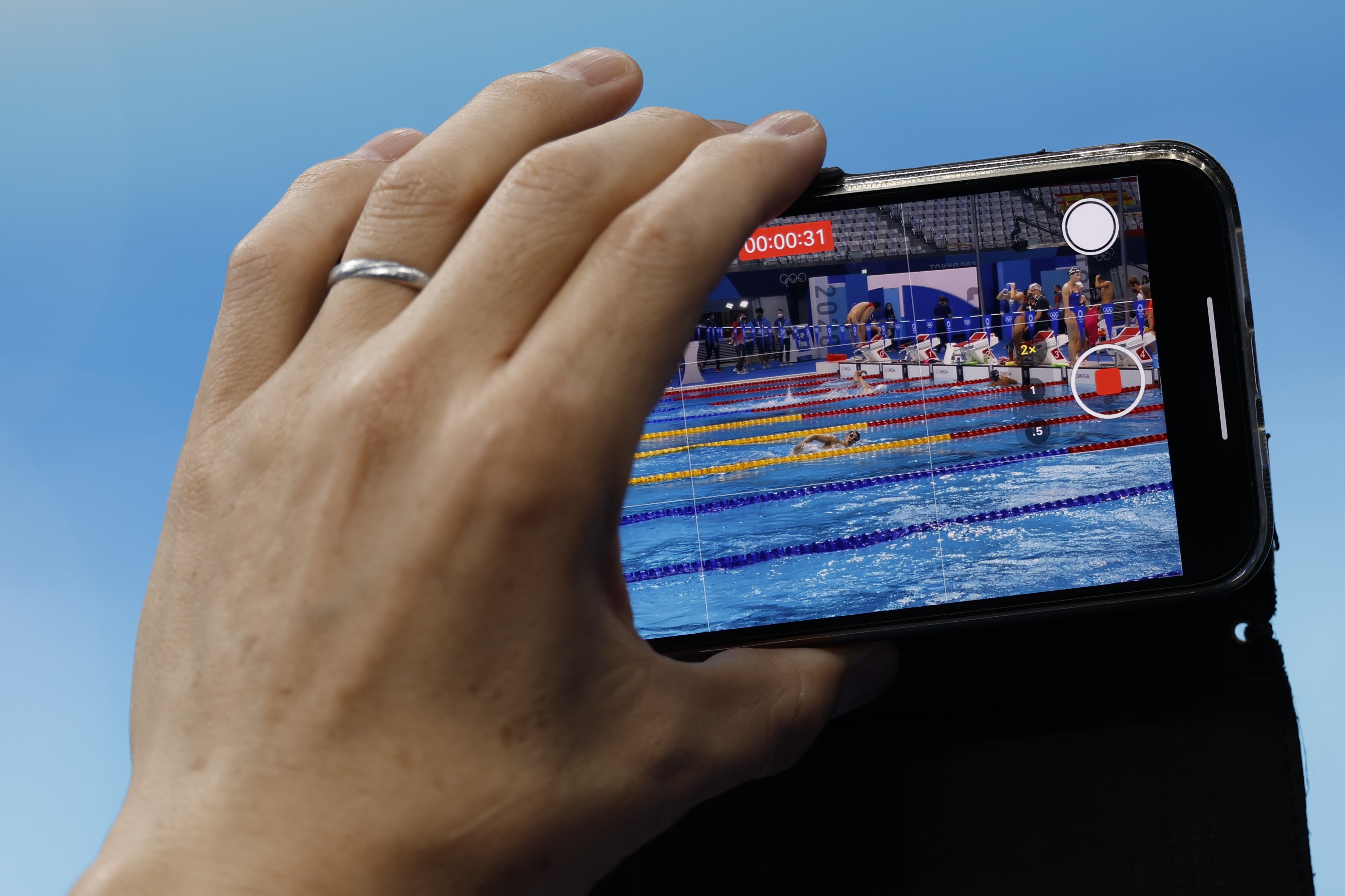 EVE1100. TOKIO, 27/07/2021.- Un asistente graba con su teléfono móvil a los nadadores japoneses mientras calientan antes de competir en los Juegos Olímpicos 2020, este martes en el Centro Acuático de Tokio (Japón). Foto Prensa Libre: EFE/ Fernando Bizerra