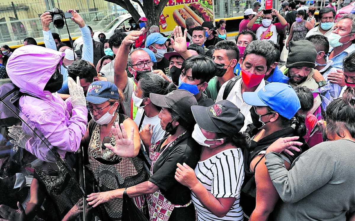 Vendedores informales se aglomeran para recibir pan de un piloto de automóvil. Este sector fue de los más golpeados por la pandemia. Foto: Hemeroteca PL