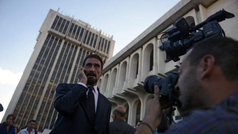 (FILES) In this file photo taken on December 04, 2012 US anti-virus software pioneer John McAfee speaks on his mobile phone in front of the Supreme Court in Guatemala City. McAfee, wanted for questioning over the murder of his neighbor last month in Belize, is seeking political asylum in Guatemala. Antivirus software pioneer John McAfee was found dead in his jail cell in Spain on June 23, 2021, officials said, shortly after a court approved his extradition to the United States where he was wanted for tax evasion. - The 75-year-old was found dead in his cell in the Brians 2 penitentiary near Barcelona 