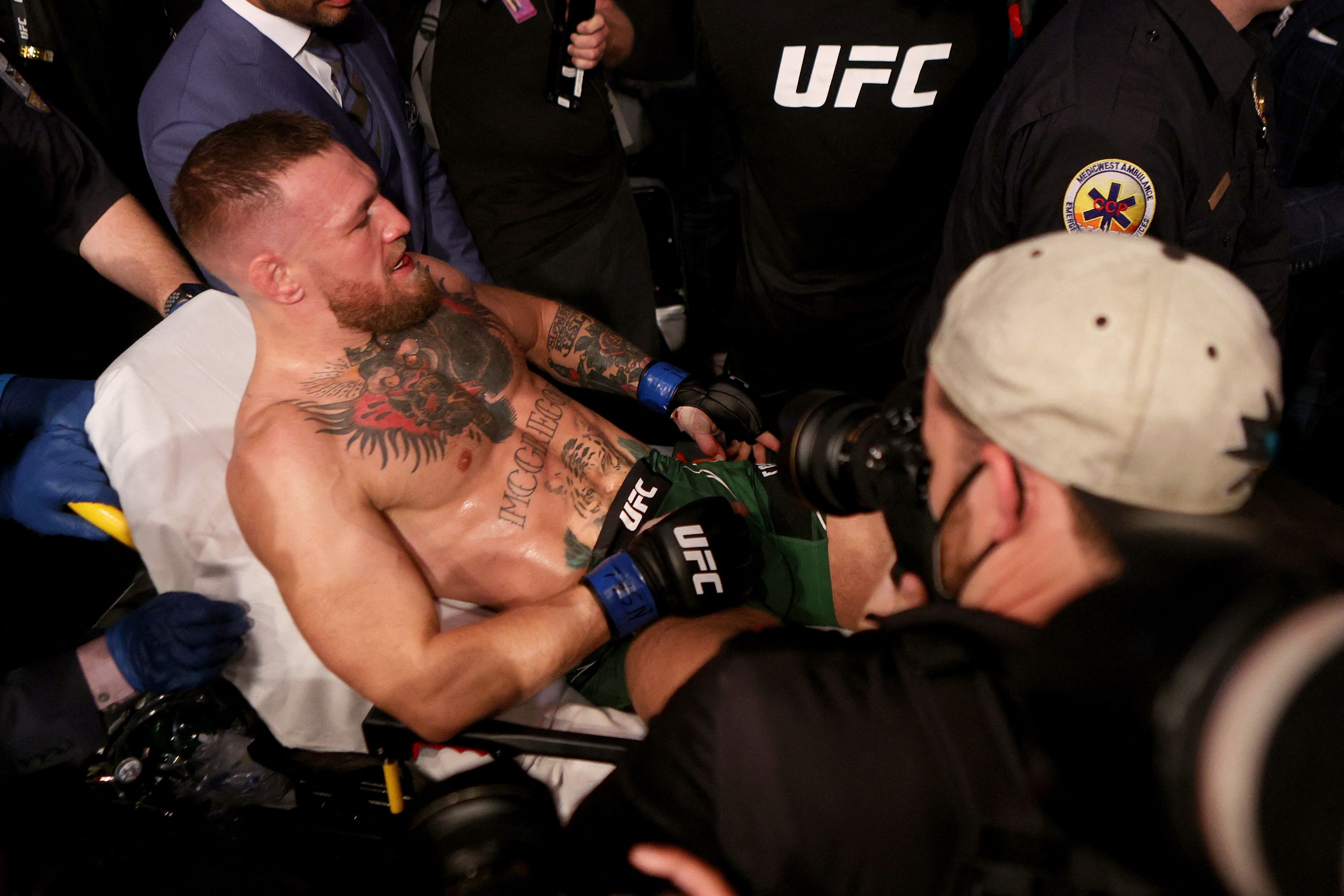 Conor McGregor mientras era sacado en camilla luego de lesionarse el tobillo. (Foto Prensa Libre: AFP)