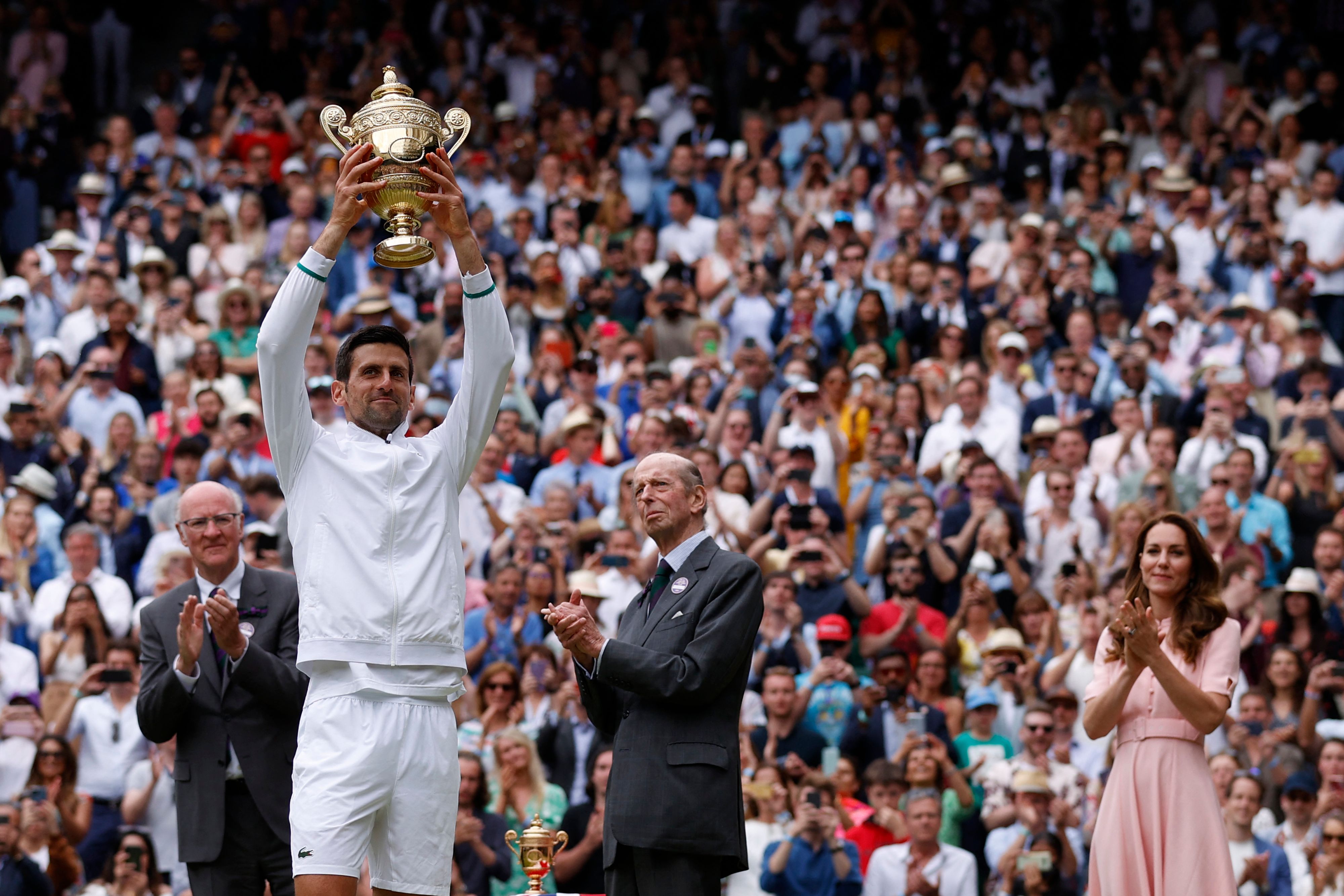 Novak Djokovic sostiene el trofeo de Winbledon después de haber vencido al italiano Matteo Berrettini en la final. Foto Prensa Libre: AFP.