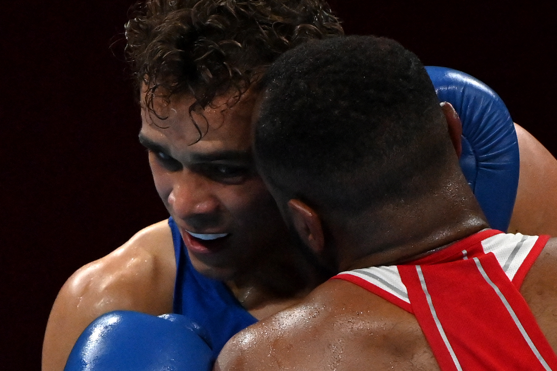 El marroquí Youness Baalla (de rojo) intentó morderle una oreja al neozelandés David Nyika durante la ronda preliminar de los pesos pesados de boxeo en los Juegos Olímpicos de Tokio 2020. La pelea se disputó en el Kokugikan Arena. Foto Prensa Libre: AFP.