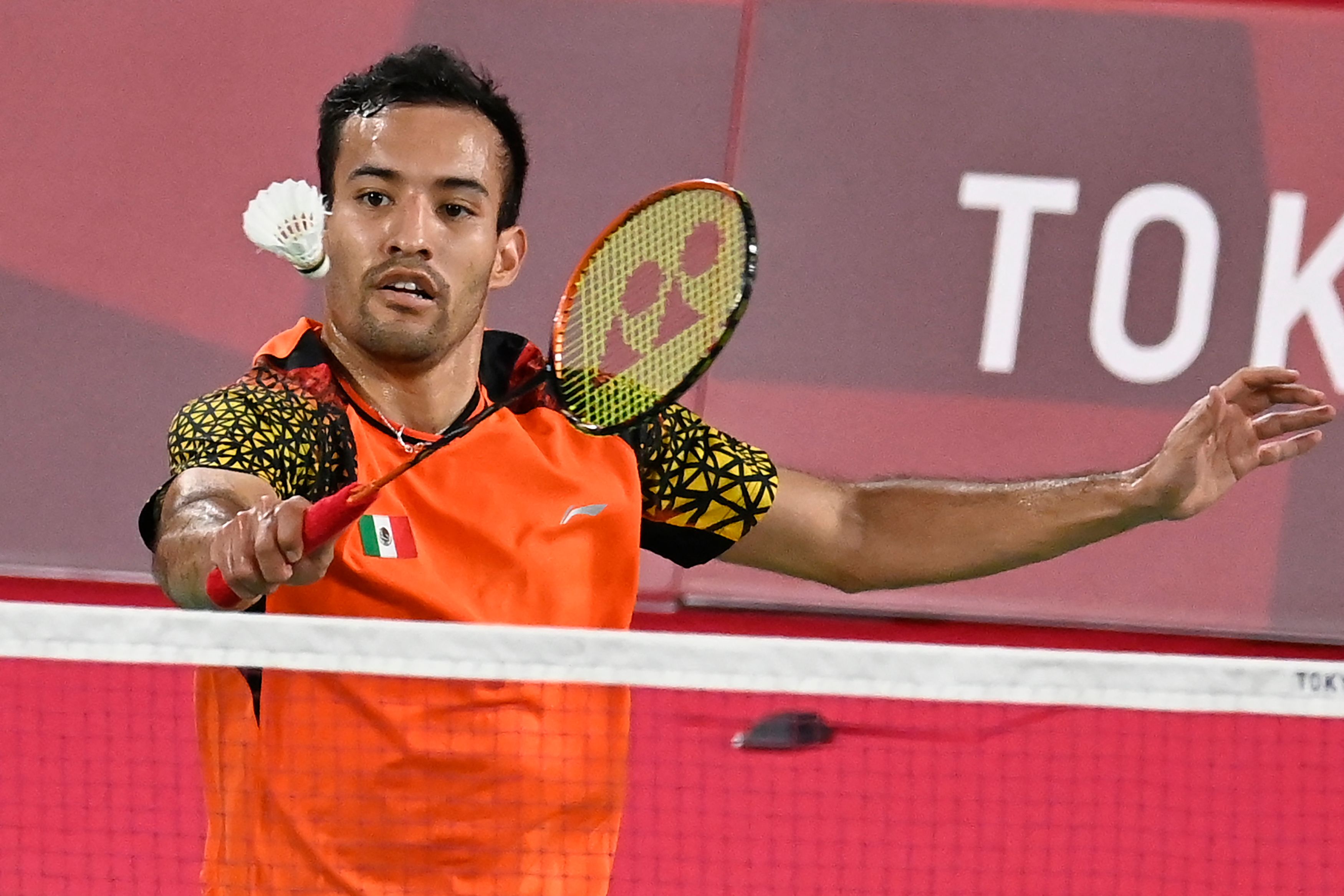 Mexico's Lino Munoz hits a shot to Hong Kong's Angus Ng Ka Long in their men's singles badminton group stage match during the Tokyo 2020 Olympic Games at the Musashino Forest Sports Plaza in Tokyo on July 24, 2021. (Photo by Alexander NEMENOV / AFP)