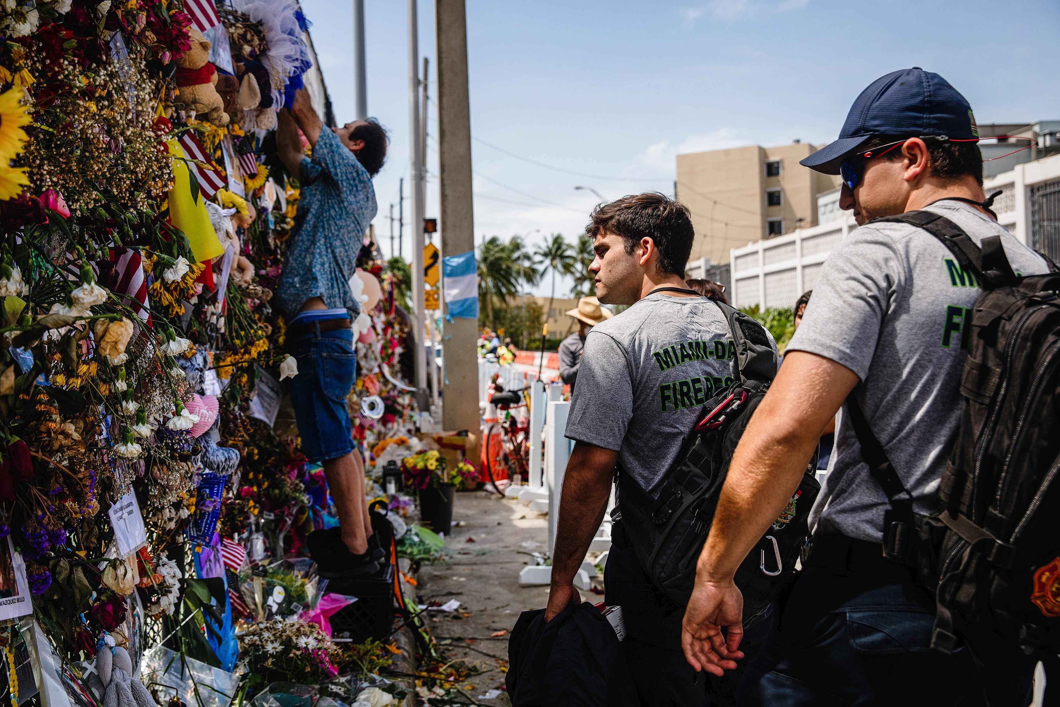 Miembros del Departamento de Rescate de Bomberos de Miami-Dade visitan un monumento cerca del lugar del colapso del condominio Champlain Towers South en Surfside, Florida, el 14 de julio de 2021. (Foto Prensa Libre: Scott McIntyre/The New York Times)
