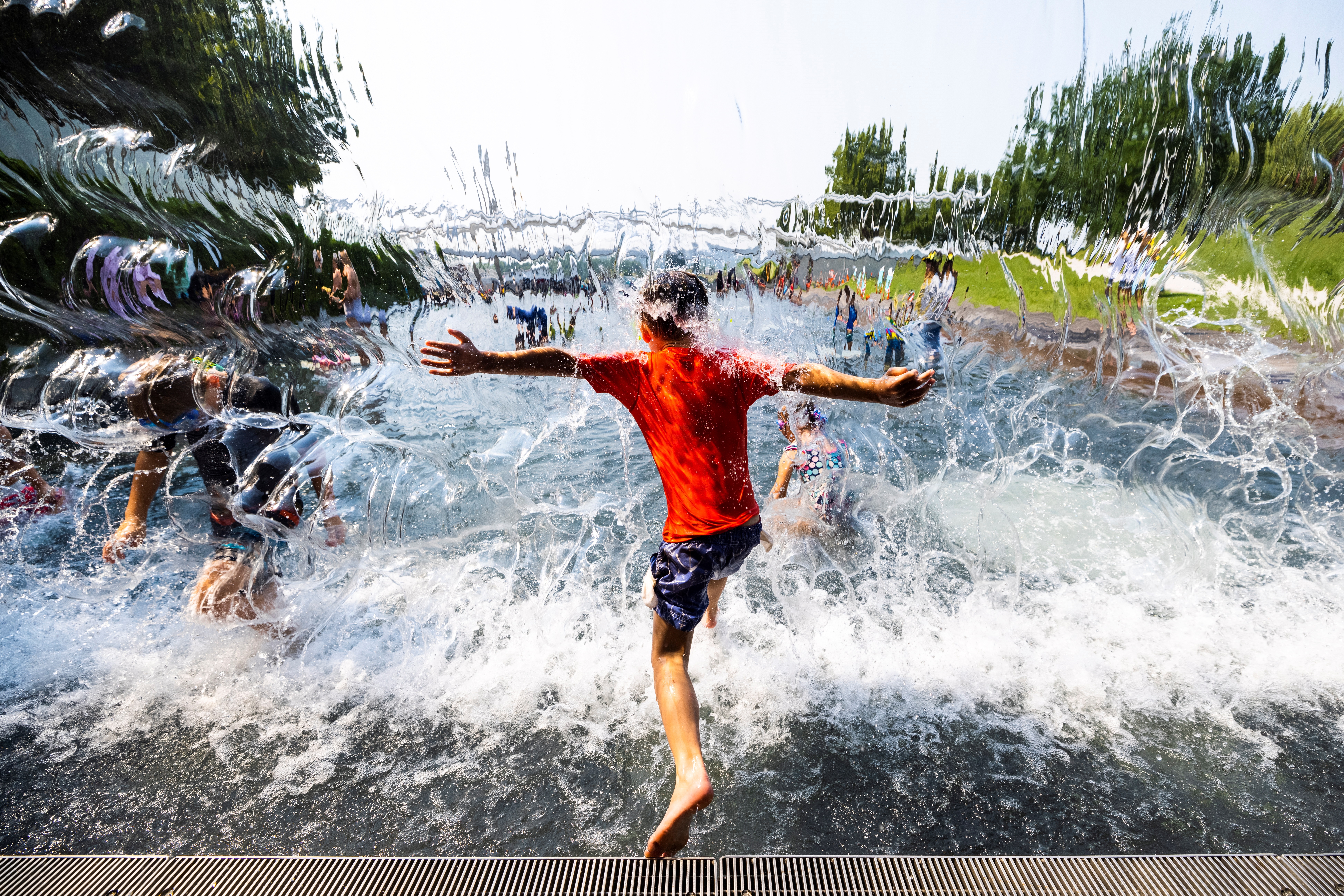 Niños se refrescan en una cascada en The Yards Park durante un clima cálido y húmedo, en Washington, Estados Unidos. Después de que históricas olas de calor se apoderaran de algunas partes del país. (Foto Prensa Libre: EFE)
