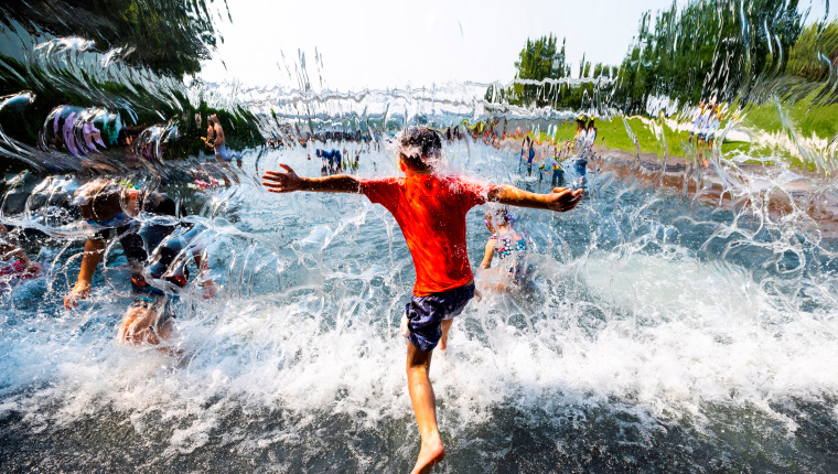 -FOTODELDIA- EA3235. WASHINGTON (ESTADOS UNIDOS), 07/07/2021.- Los niños se refrescan en una cascada en The Yards Park durante un clima cálido y húmedo hoy, en Washington (Estados Unidos). Después de que históricas olas de calor se apoderaran de algunas partes del país, La capital de la nación está experimentando temperaturas en los 90 con un índice de calor abrasador que podría alcanzar o superar los 100 grados Fahrenheit (37,7 grados Celsius). EFE / EPA / JIM LO SCALZO