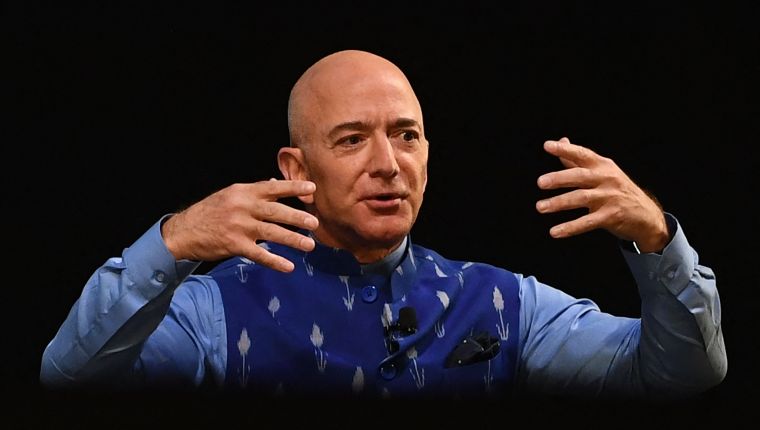 (FILES) In this file photo the CEO of Amazon Jeff Bezos (R) gestures as he addresses the Amazon's annual Smbhav event in New Delhi on January 15, 2020. - As he prepares to blast off into a new career stage, Jeff Bezos leaves an enduring legacy after transforming Amazon from a modest online bookseller into one of the world's most powerful corporations. Bezos, 57, was set to hand over the job of Amazon chief executive on July 5, 2021 to Andy Jassy and turn his attention to his private space exploration firm, philanthropy and other endeavors. He will retain a key role, however, as executive chair at the technology and e-commerce colossus he founded 27 years ago. (Photo by Sajjad HUSSAIN / AFP)