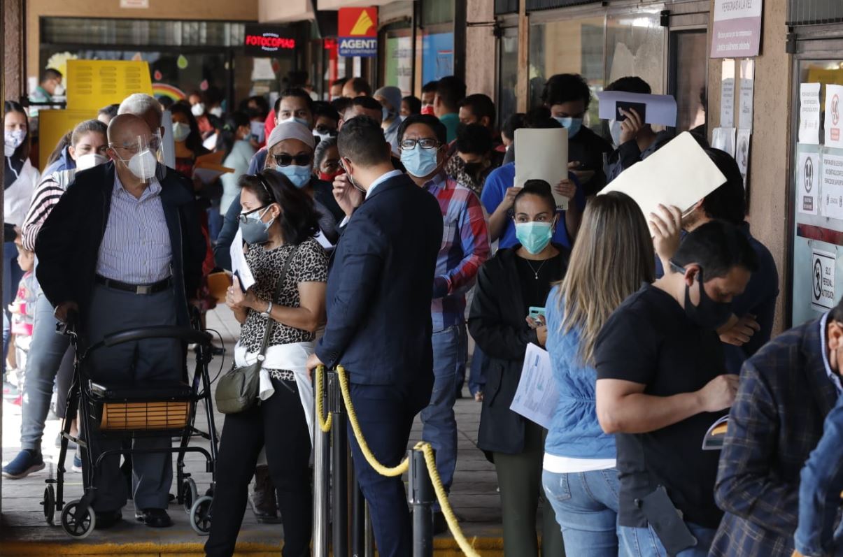 Varias personas llegan al Centro de Emisión de Pasaportes en la capital de Guatemala para que les coloquen un sticker en el pasaporte vencido. (Foto Prensa Libre: Esbin García)