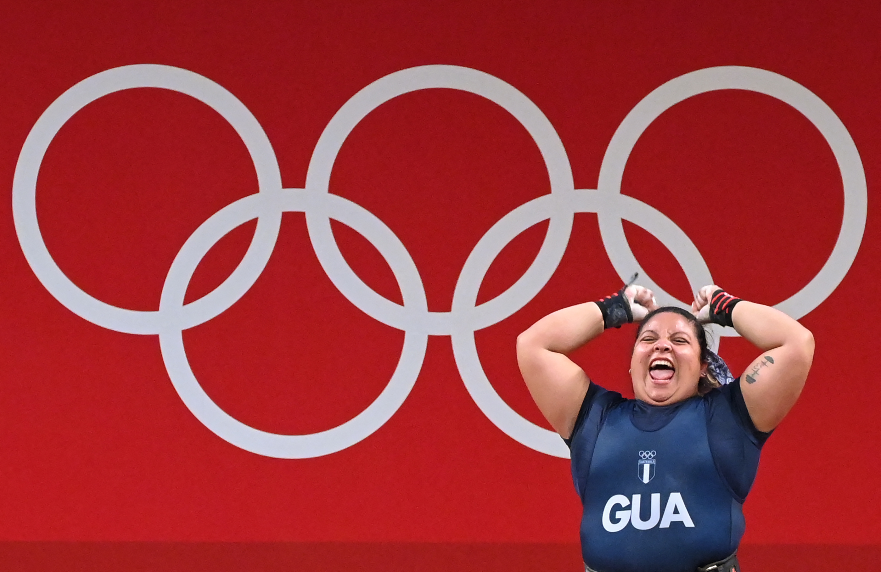 Guatemala's Scarleth Ucelo Marroquin reacts as she competes in the women's +87kg weightlifting competition during the Tokyo 2020 Olympic Games at the Tokyo International Forum in Tokyo on August 2, 2021. (Photo by Mohd RASFAN / AFP)