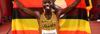 Joshua Cheptegei de Uganda con la bandera de su país la victoria en los 5000m que le dan su primera medalla de oro olímpica. Foto Prensa Libre: AFP.