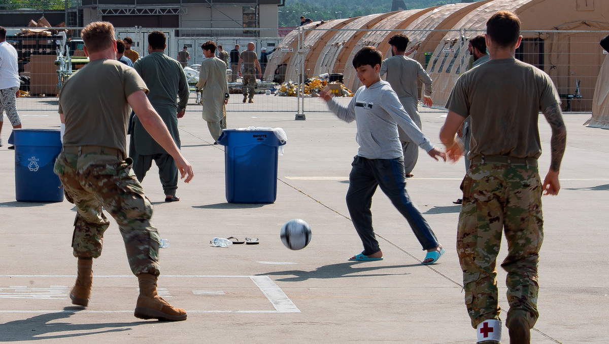 Ramstein Air Base (Germany), 21/08/2021.- A handout photo made available by the US Air Force via Defense Visual Information Distribution Service (DVIDS) showing US Air Force Airmen play soccer with Afghan evacuees at Ramstein Air Base, Germany, 21 August 2021 (Issued 22 August 2021). Ramstein Air Base is providing safe, temporary lodging for evacuees from Afghanistan as part of Operation Allies Refuge. This operation is facilitating the quick, safe evacuation of US citizens, Special Immigrant Visa applicants, and other at-risk Afghans from Afghanistan. Evacuees will receive support, such as temporary lodging, food and water and access to medical care as well as religious care at Ramstein Air Base while preparing for onward movements to their final destinations. (Afganistán, Alemania) EFE/EPA/Airman Edgar Grimaldo / US AIR FORCE via DVIDS / HANDOUT Released Col. Robert Firman U.S. Air Force in Europe-Air Force Africa Public Affairs robert.firman·us.af.mil HANDOUT EDITORIAL USE ONLY/NO SALES