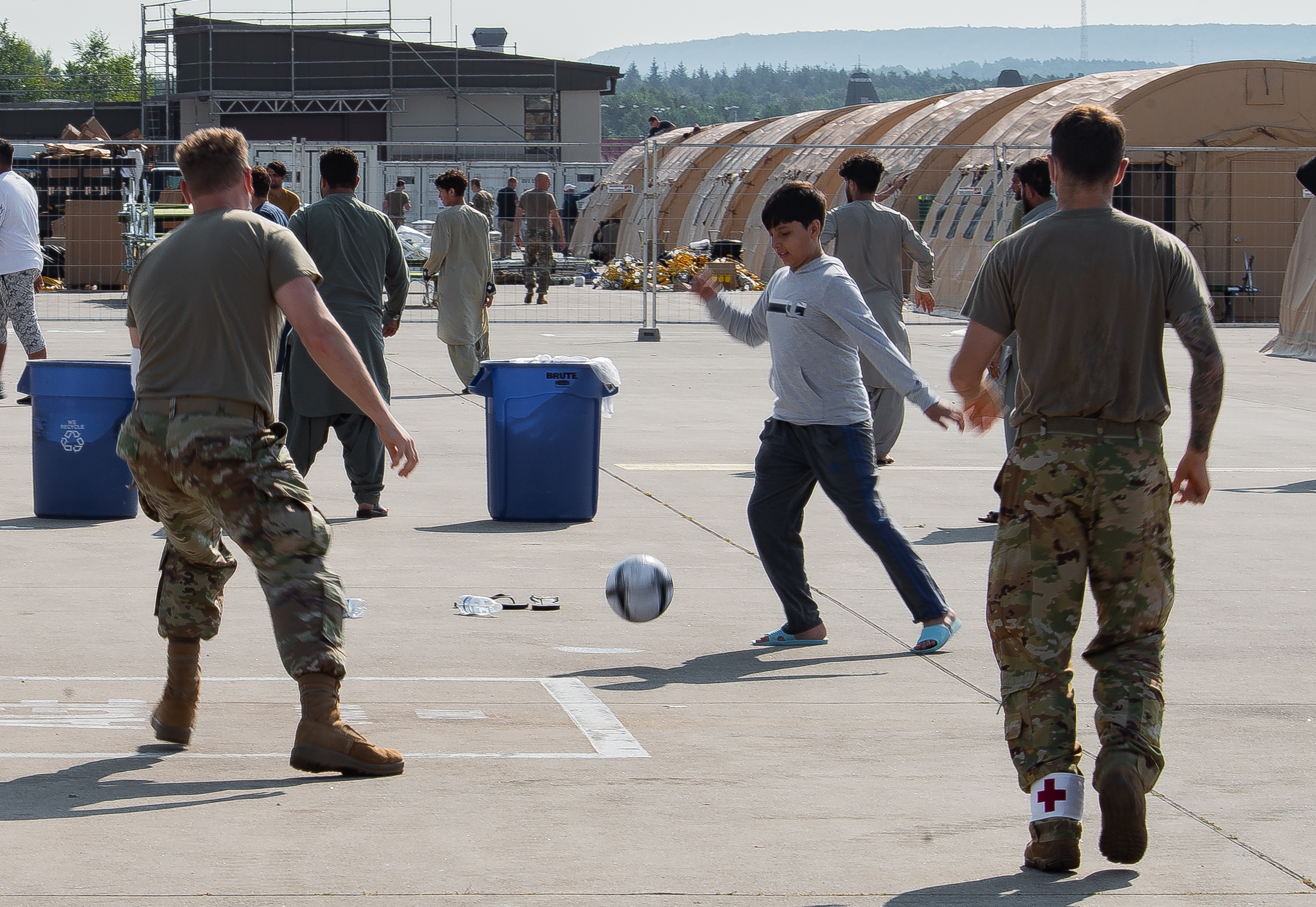 En una foto brindada por la Fuerza Aérea de EE. UU. se ve a militares jugando futbol con jóvenes evacuados de Afganistán, en la base aérea Ramstein, Alemania. (Foto Prensa Libre:  EFE)