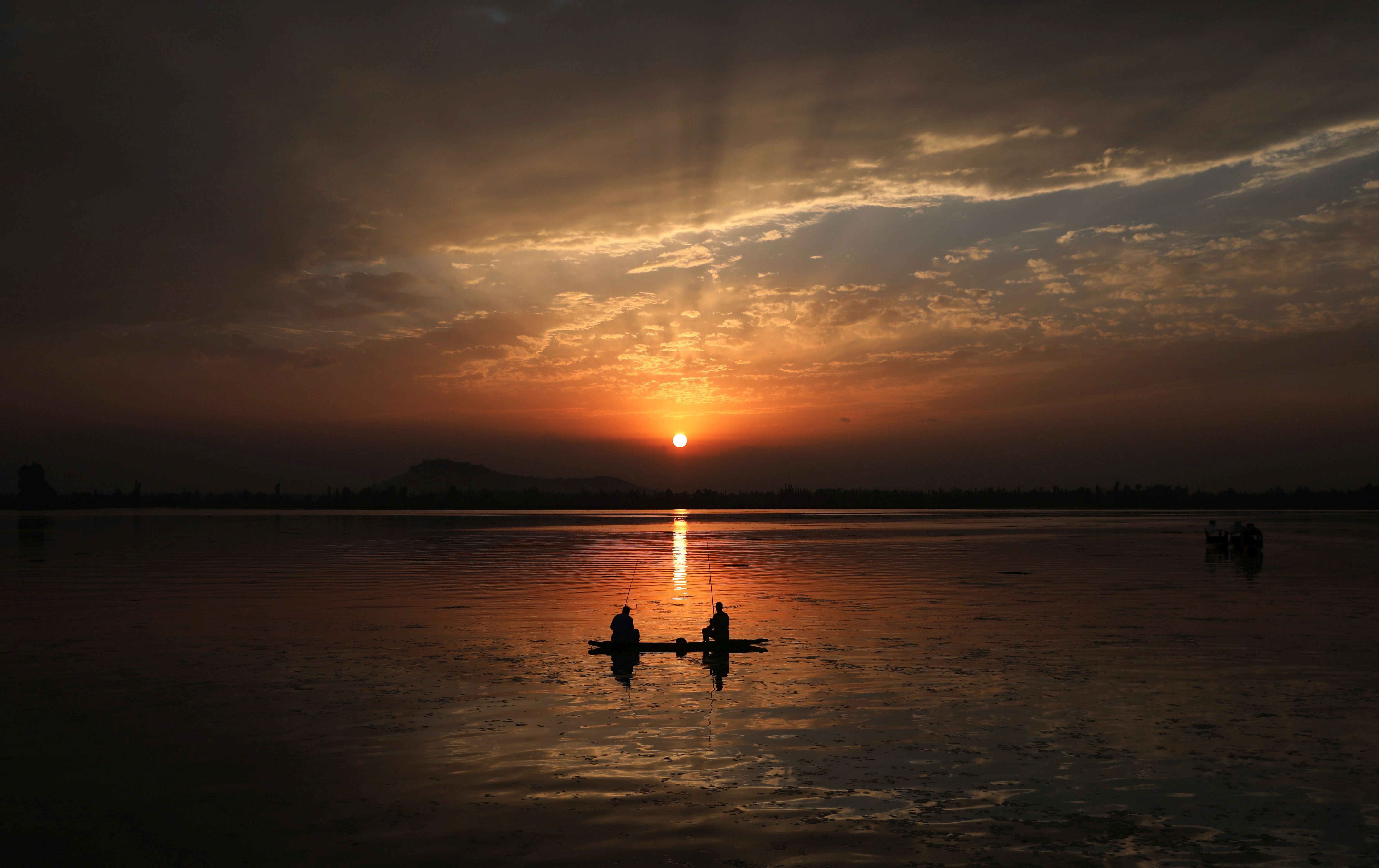 -FOTODELDIA- EA6745. SRINAGAR (INDIA), 28/08/2021.- Pescadores al atardecer en el lago Dal en Srinagar, capital de verano de la Cachemira india, este sábado, cuando las temperaturas comienzan a descender tras una ola de calor. EFE/ Farooq Khan