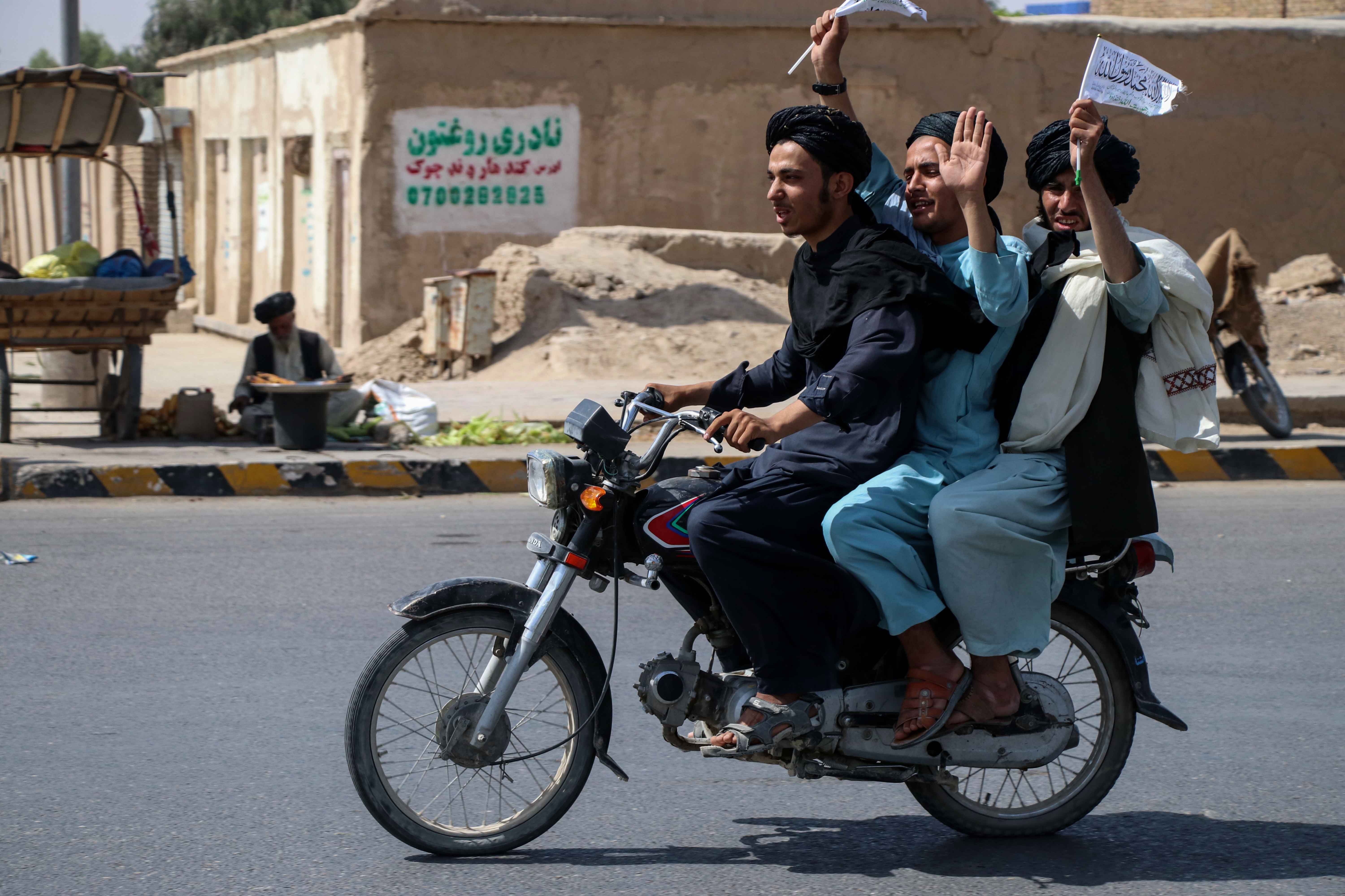 Talibanes celebran la retirada de las fuerzas estadounidenses por las calles de Kandahar, Afganistán. (Foto Prensa Libre: EFE)
