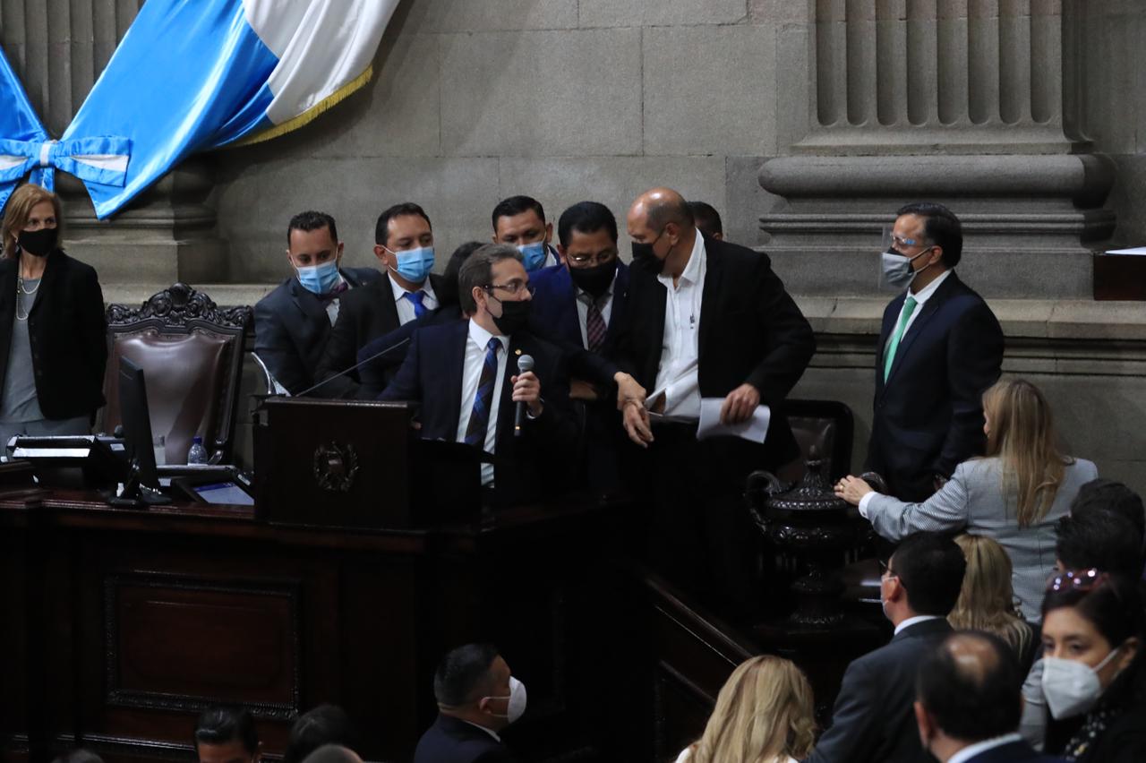 El diputado Orlando Blanco, de la Bancada UNE, le arrebata el documento que incluye el decreto del estado de Calamidad a parlamentario Jorge García. (Foto Prensa Libre: Élmer Vargas)