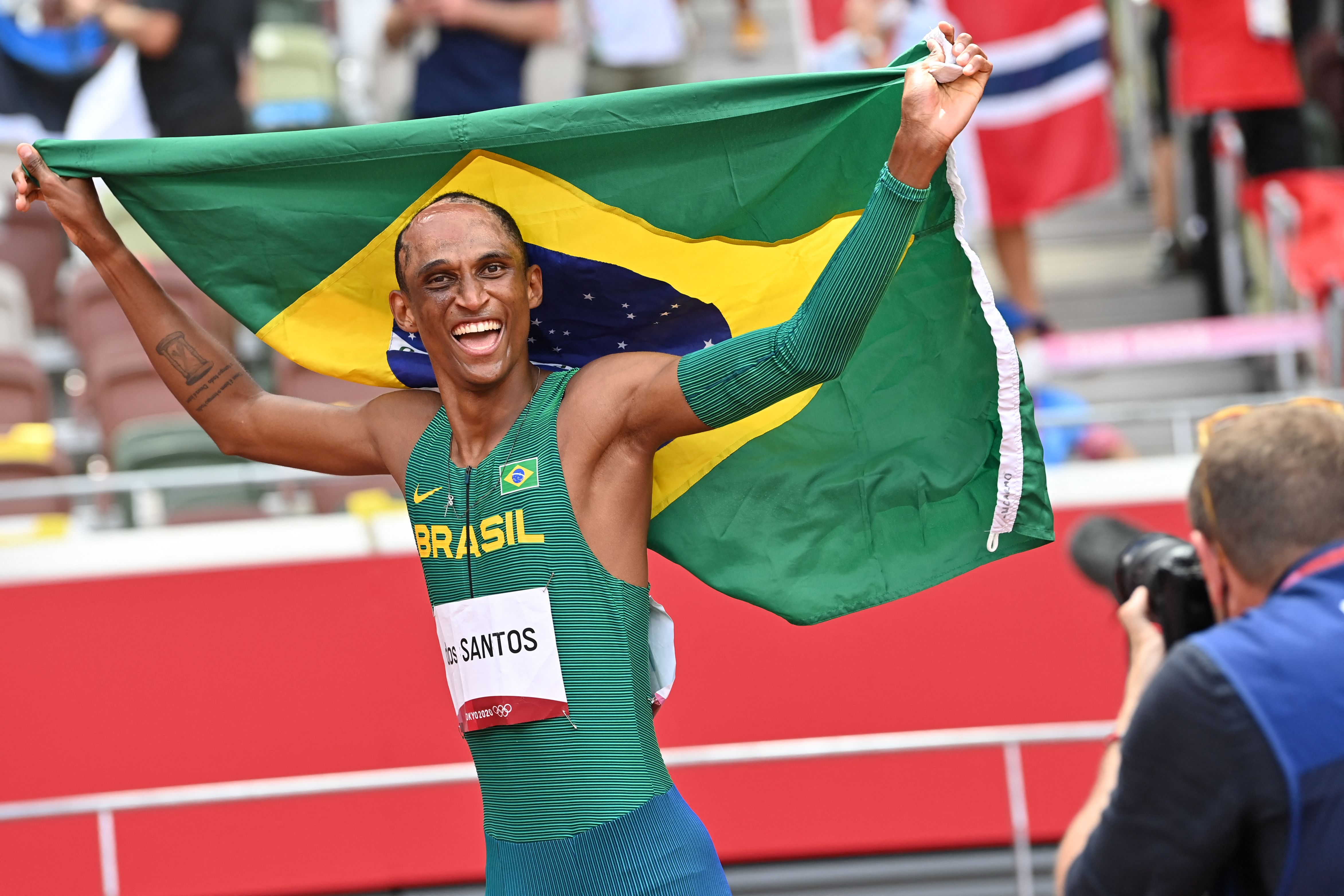 Third-placed Brazil's Alison Dos Santos celebrates after competing in the men's 400m hurdles final during the Tokyo 2020 Olympic Games at the Olympic Stadium in Tokyo on August 3, 2021. (Photo by Andrej ISAKOVIC / AFP)