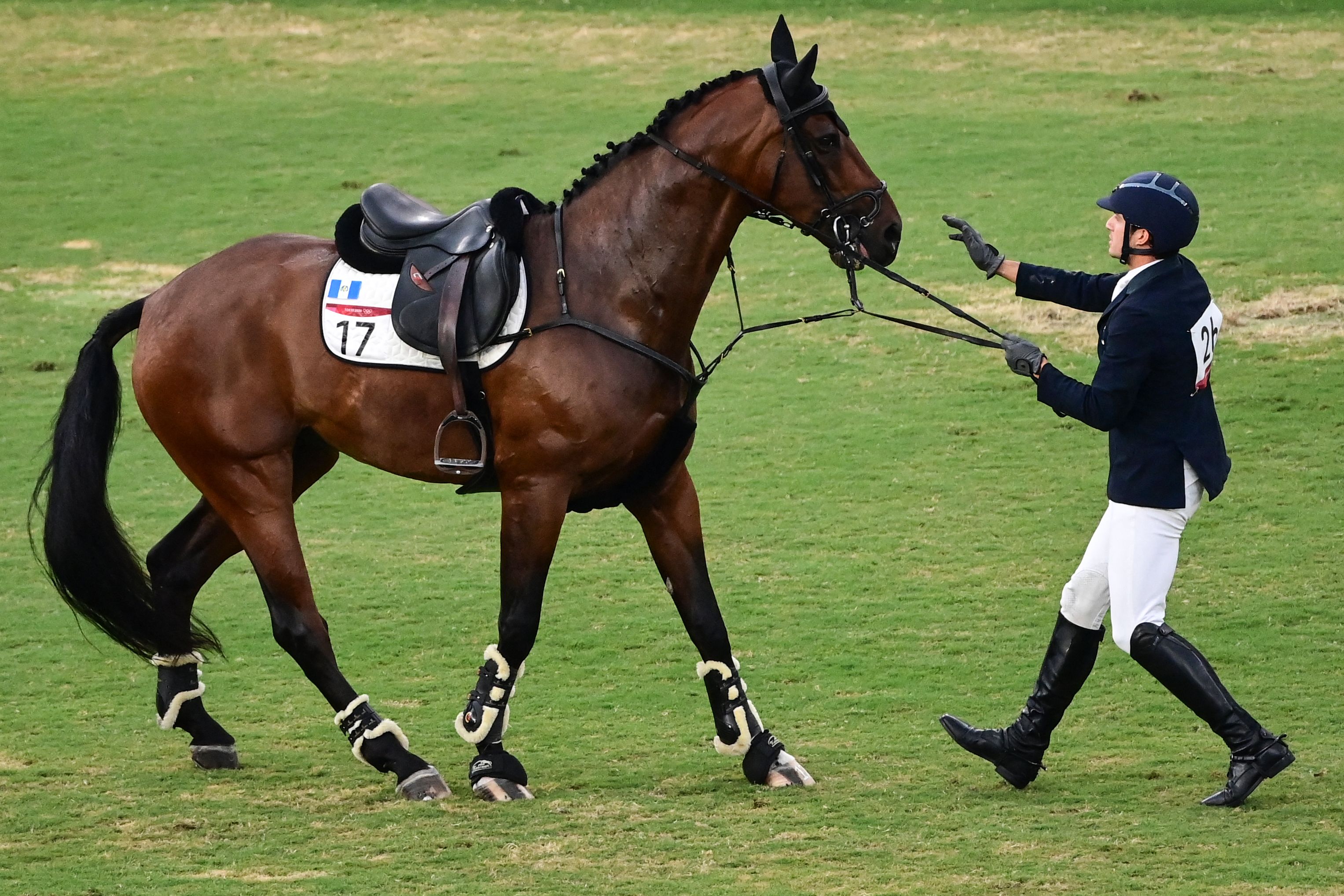 Charles Fernandez habla con el caballo Fluoriet intentando calmarlo luego de caerse durante la competencia individual masculina de equitación. (Foto Prensa Libre: AFP)