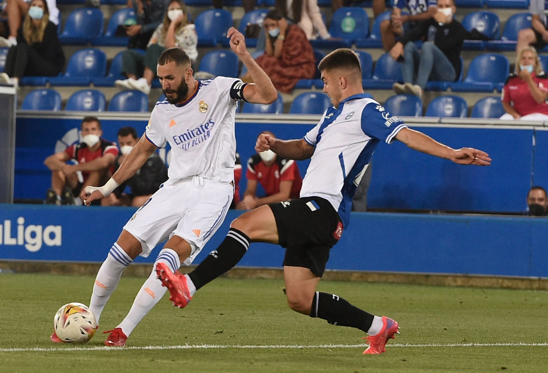 Real Madrid's French forward Karim Benzema (L) vies with Alaves' Spanish midfielder Pere Pons during the Spanish League football match between Alaves and Real Madrid at the Mendizorroza stadium in Vitoria on August 14, 2021. (Photo by Josep LAGO / AFP)
