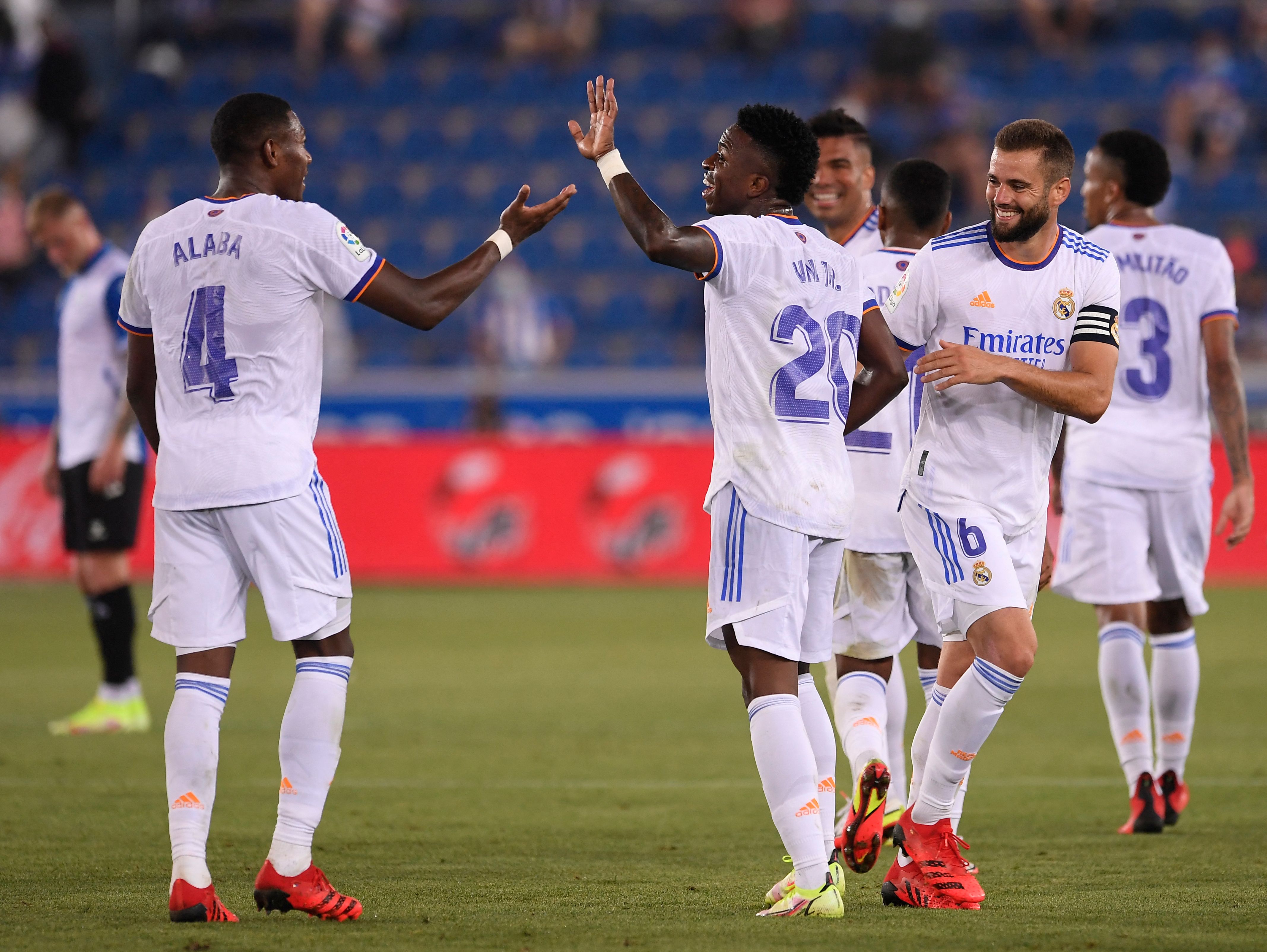 Real Madrid's Brazilian forward Vinicius Junior (C) celebrates with teammates after scoring during the Spanish League football match between Alaves and Real Madrid at the Mendizorroza stadium in Vitoria on August 14, 2021. (Photo by Josep LAGO / AFP)