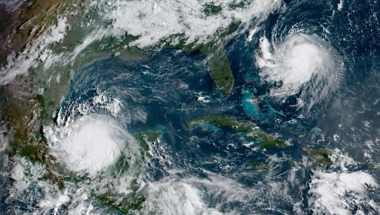 This National Oceanic and Atmospheric Administration(NOAA) satellite handout image shows Hurricane Grace (lower L) and Tropical Storm Henri (upper R) at 13:30UTC, on August 20, 2021. - Grace moved westwards in the Gulf of Mexico, regaining hurricane strength ahead of an expected second landfall August 20, after tearing through the Yucatan Peninsula. The US National Hurricane Center issued a hurricane watch for Henri as the system heads toward New England, and is on track to impact the region as a hurricane by August 22. (Photo by Handout / NOAA/GOES / AFP) / RESTRICTED TO EDITORIAL USE - MANDATORY CREDIT 