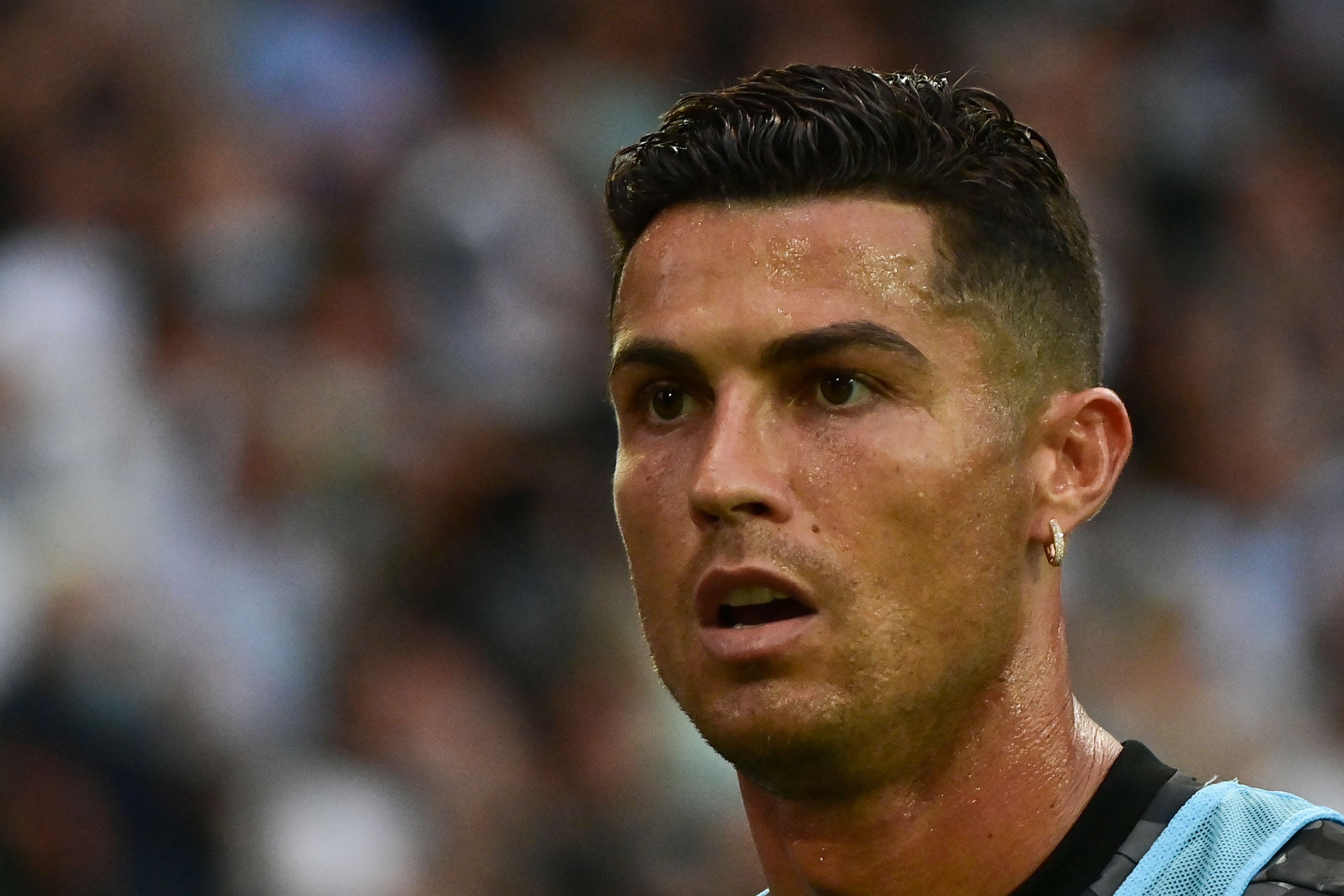 In this photograph taken on August 22, 2021, Juventus' Portuguese forward Cristiano Ronaldo looks on prior to the Italian Serie A football match between Udinese and Juventus at the Dacia Arena Stadium in Udine. - Cristiano Ronaldo will not train with Juventus on August 27, the Serie A giants confirmed to AFP, as rumours of an imminent move to Manchester City gather pace. Widespread media reports said that Ronaldo left Juve's Continassa training centre before the start of Friday's session. Sky Sport Italia reported that the five-time Ballon d'Or winner arrived in the morning to say goodbye to his teammates before leaving at around 10:45 am local time (0845 GMT). Asked by AFP if Ronaldo would be training with his Juve teammates, a club spokeswoman confirmed that he would not. (Photo by MIGUEL MEDINA / AFP)