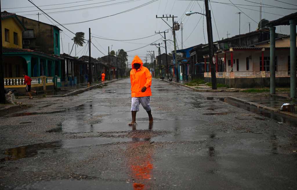 A man walks under the rain in Batabano, Mayabeque province, about 60 km south of Havana, on August 27, 2021, as Hurricane Ida passes through eastern Cuba. (Photo by Yamil LAGE / AFP)