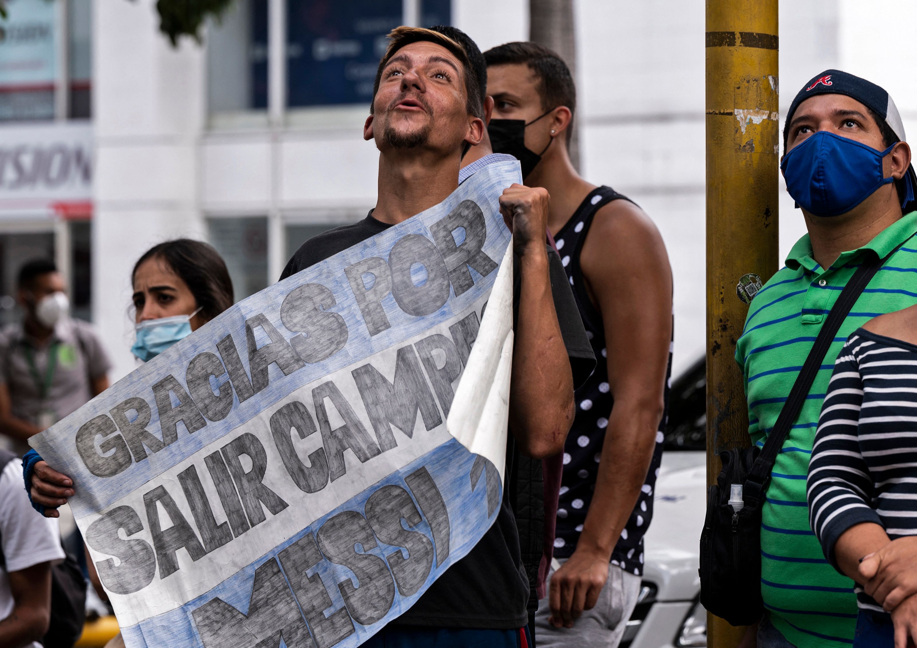 Un venezolano, seguidor del argentino, Lionel Messi, sostiene un cartel en donde le agradece por haber salido campeón en la Copa América. El astro argentino llegó este 31 de agosto para jugar ante Venezuela en las eliminatorias sudamericanas. Foto Prensa Libre: AFP.