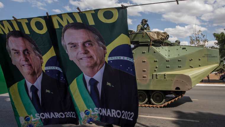 tanque en un desfile pasa por delante de las pancartas de la campaña del presidente Jair Bolsonaro en Brasilia, Brasil, el martes 10 de agosto de 2021. (Foto Prensa Libre: Victor Moriyama/The New York Times)
