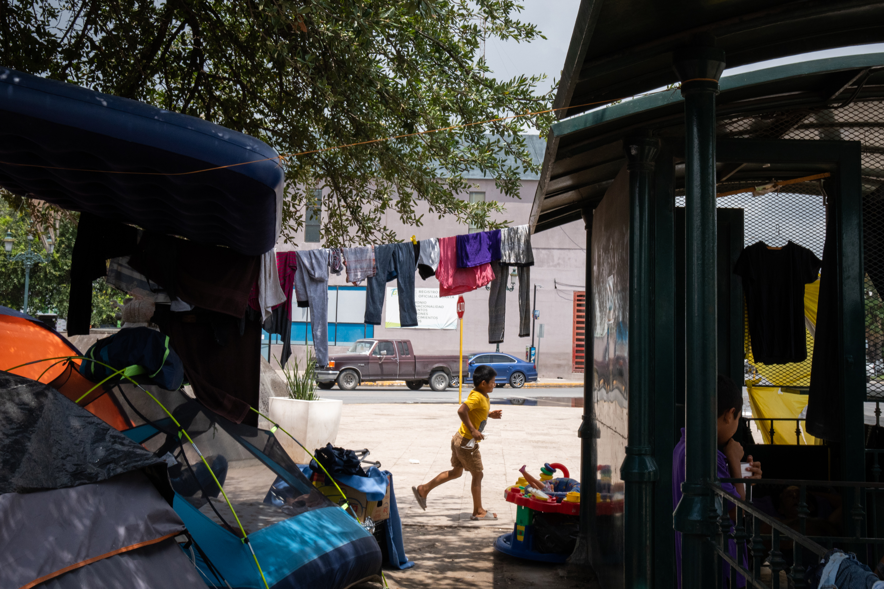 Un niño corre alrededor de un campamento provisional de migrantes instalado en una plaza del centro de Reynosa, México, el 6 de agosto de 2021. (Sarahbeth Maney/The New York Times)