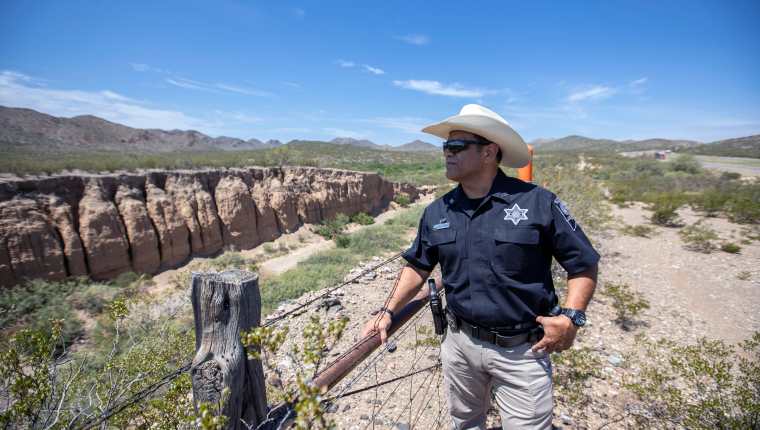 El sheriff Oscar Carrillo del condado de Culberson observa el paisaje desértico cerca de la Interestatal 10, arriba a la derecha, en Van Horn, Texas, el 10 de agosto de 2021. (Ivan Pierre Aguirre/The New York Times)