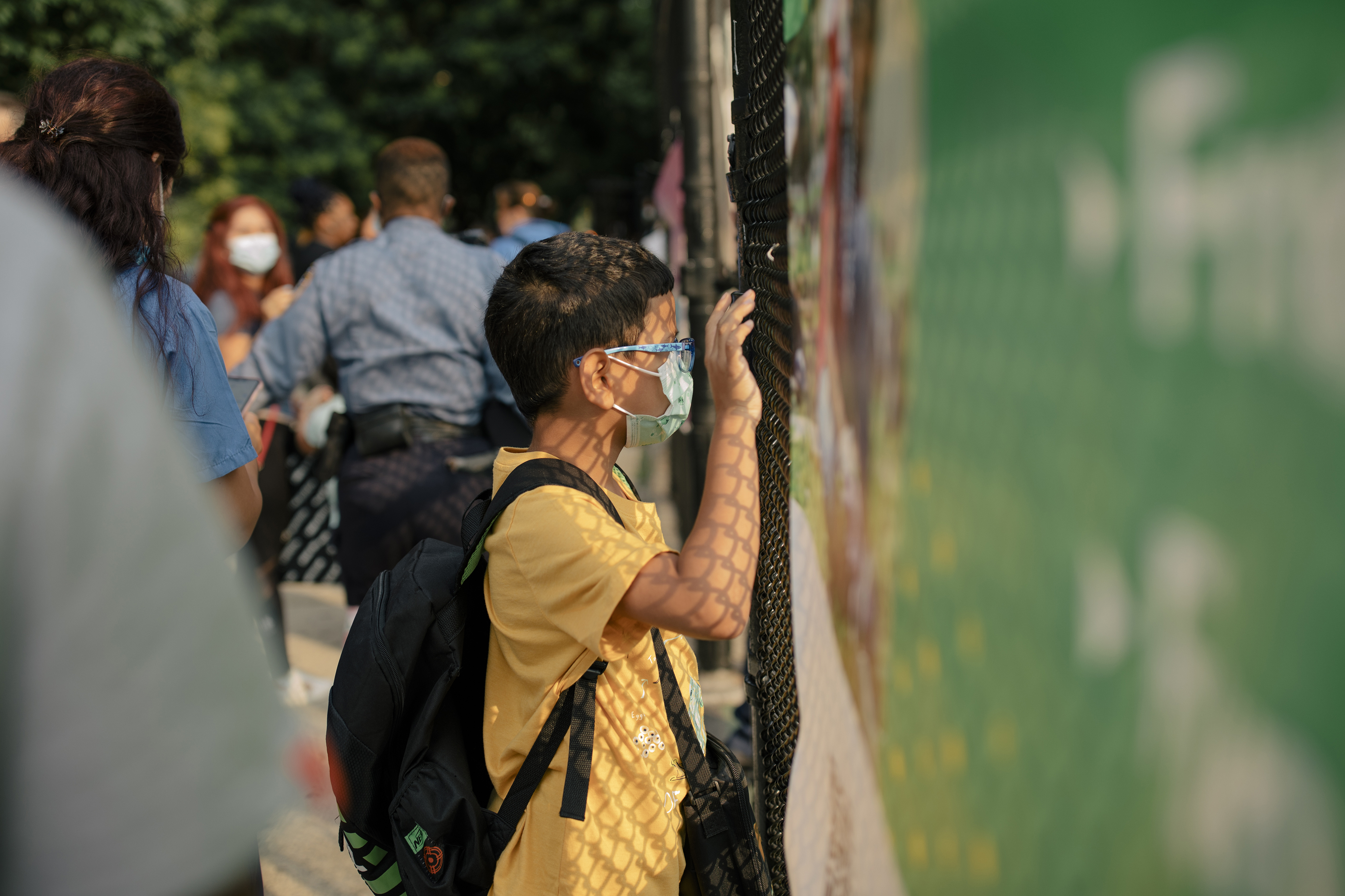 Un estudiante mira a través de una valla en una escuela del barrio Harlem del Este de Manhattan, el 6 de julio de 2021. (Foto Prensa Libre: Jose A. Alvarado Jr./The New York Times)