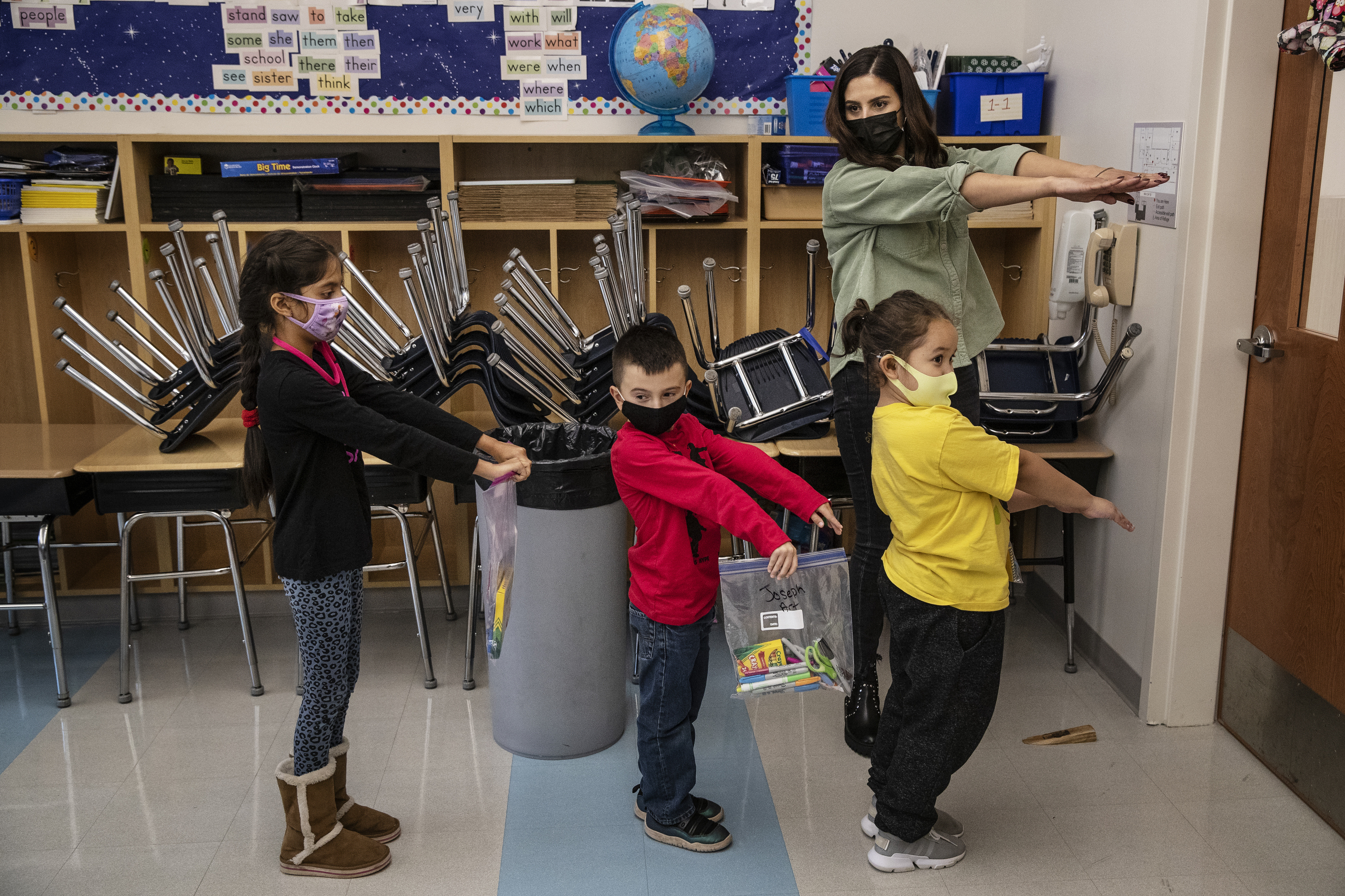 Una maestra muestra a niños de primero primaria como mantener la distancia social, como parte de las medidas para prevenir el contagio de covid-19 en una escuela de Nueva Jersey. (Foto Prensa Libre: Victor J. Blue/The New York Times)