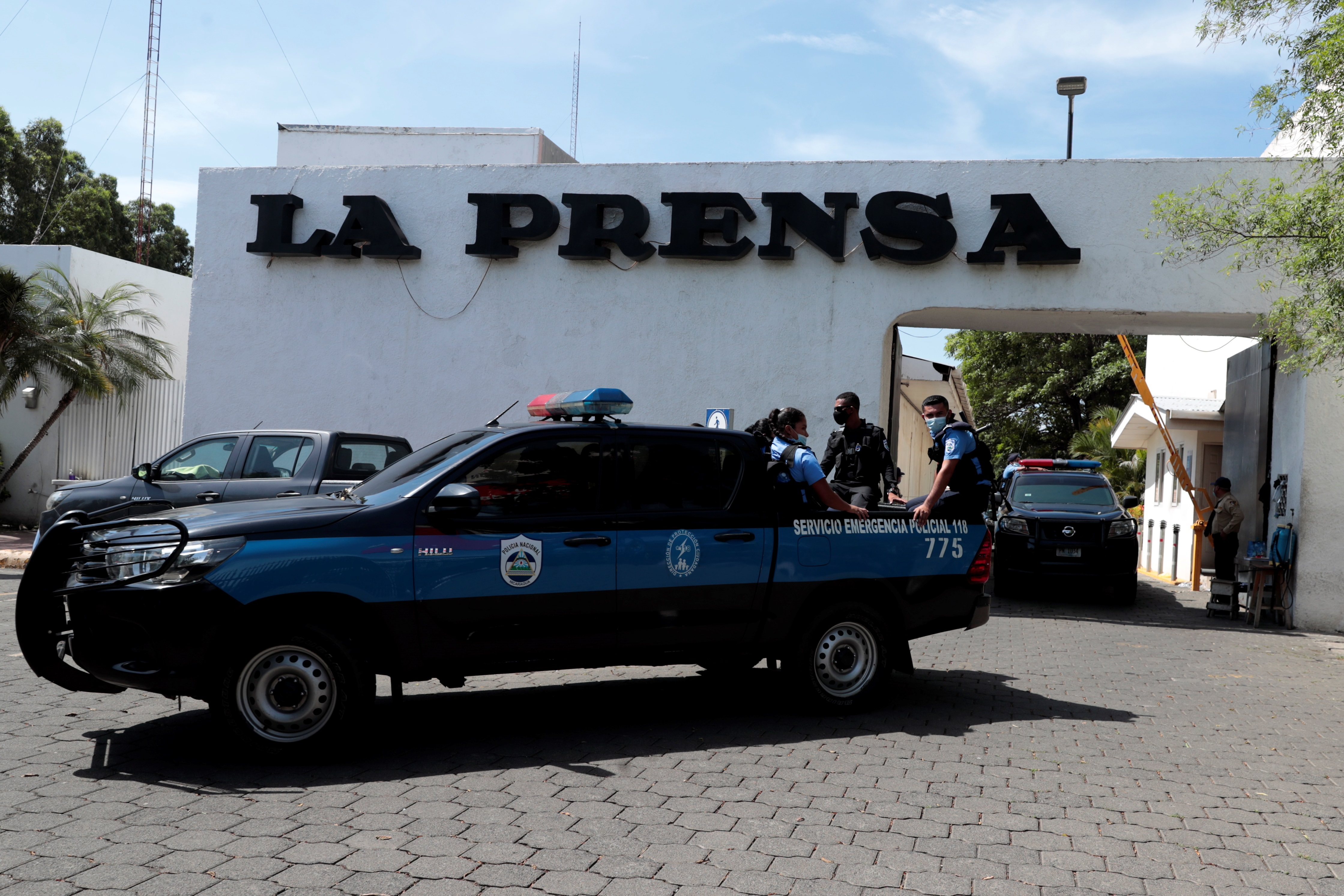 Miembros de la policía permanecen en la entrada de una propiedad de la Editorial "La Prensa" durante un operativo de allanamiento. (Foto Prensa Libre: EFE)