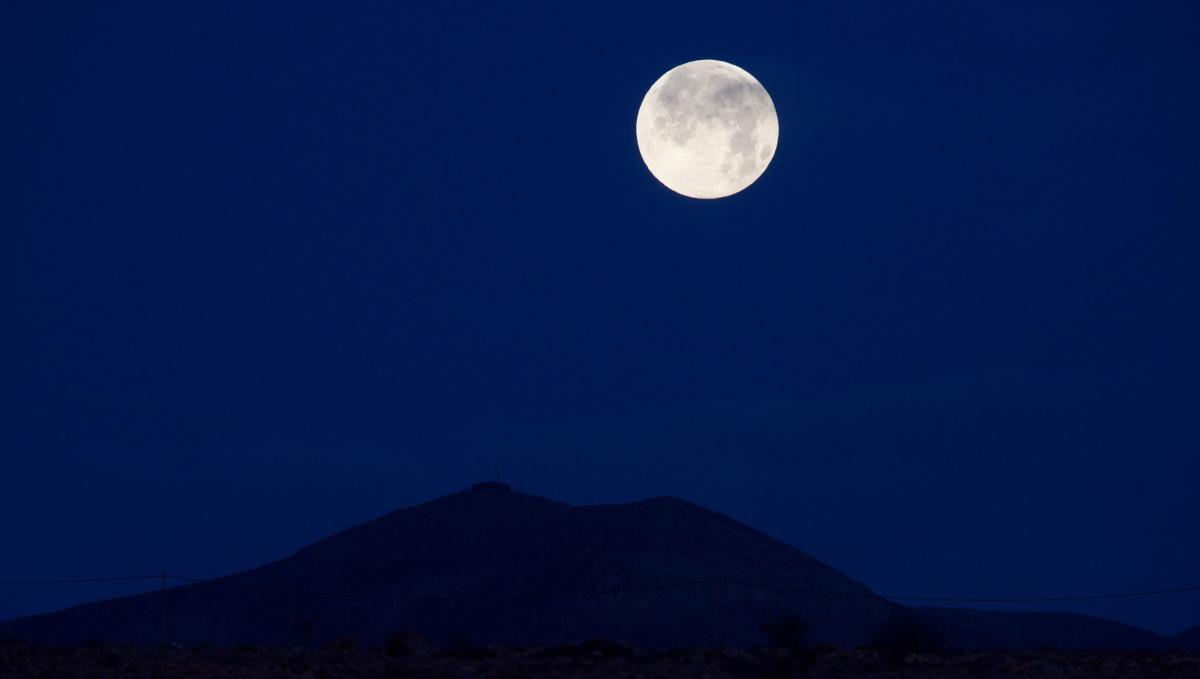 GRAFCAN8116. PUERTO DEL ROSARIO (FUERTEVENTURA), 27/04/2021.- La súper luna rosa al amanecer de este martes sobre la localidad de Los Estancos, en Puerto del Rosario, en la isla de Fuerteventura. Este fenómeno astronómico se produce gracias a que la luna se encuentra en fase llena y a que está situada en el punto de su órbita más cercano a la Tierra, llamado perigeo, lo que facilita que el satélite luzca más brillante y con un tamaño mayor de lo normal. EFE/ Carlos De Saá