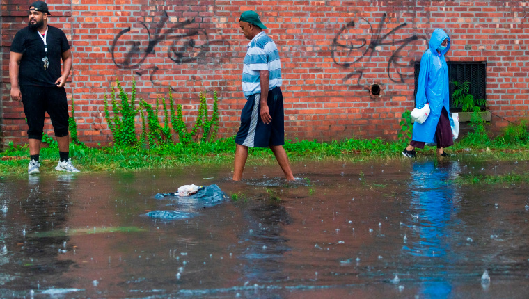 New York (United States), 22/08/2021.- People navigate a flooded sidewalk as rain from Tropical Storm Henri falls in the Queens borough of New York, New York, USA, 22 August 2021. The storm made landfall east of New York near the Connecticut and Rhode Island borders early in the day but is still expected deliver large amounts of rain to the city. (Estados Unidos, Nueva York) EFE/EPA/JUSTIN LANE
