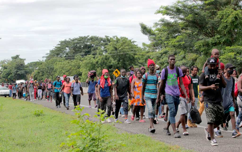 MEX488. TAPACHULA (MÉXICO), 01/09/2021.- Una caravana de migrantes en su mayoría haitianos, caminan hoy en una carretera en el municipio de Tapachula, estado de Chiapas (México). El Instituto Nacional de Migración (INM) de México informó este miércoles que busca instalar un campamento humanitario para migrantes haitianos en el estado de Chiapas, frontera con Guatemala, donde se brinde atención a ciudadanos de aquel país que esperan resolución de refugio o asilo. EFE/ Juan Manuel Blanco