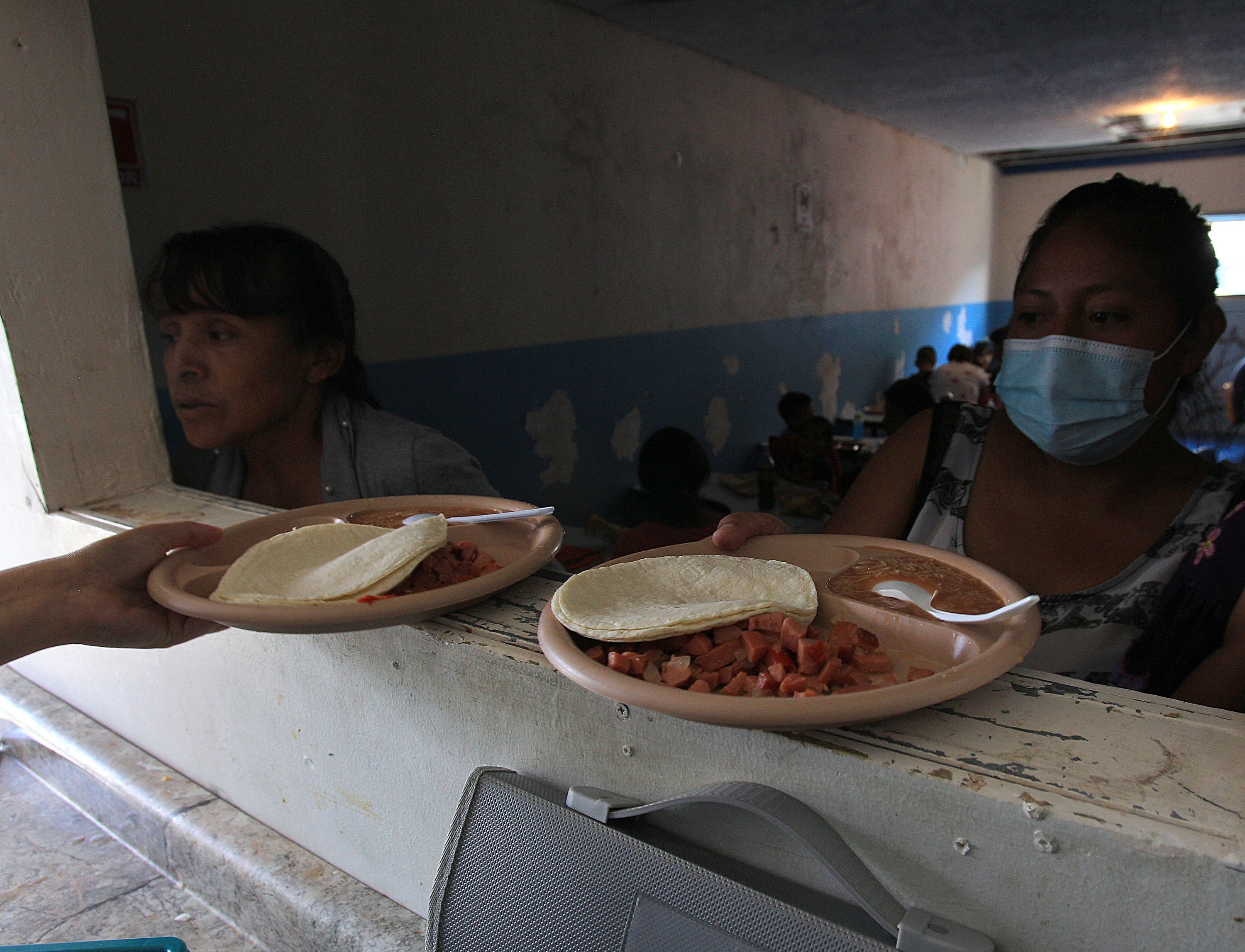 Migrantes centroamericanos contagiados en su mayoría por covid-19 reciben alimentos en el comedor del albergue "Esperanza para todos", en Ciudad Juárez,  Chihuahua, México. (Foto Prensa Libre: EFE)