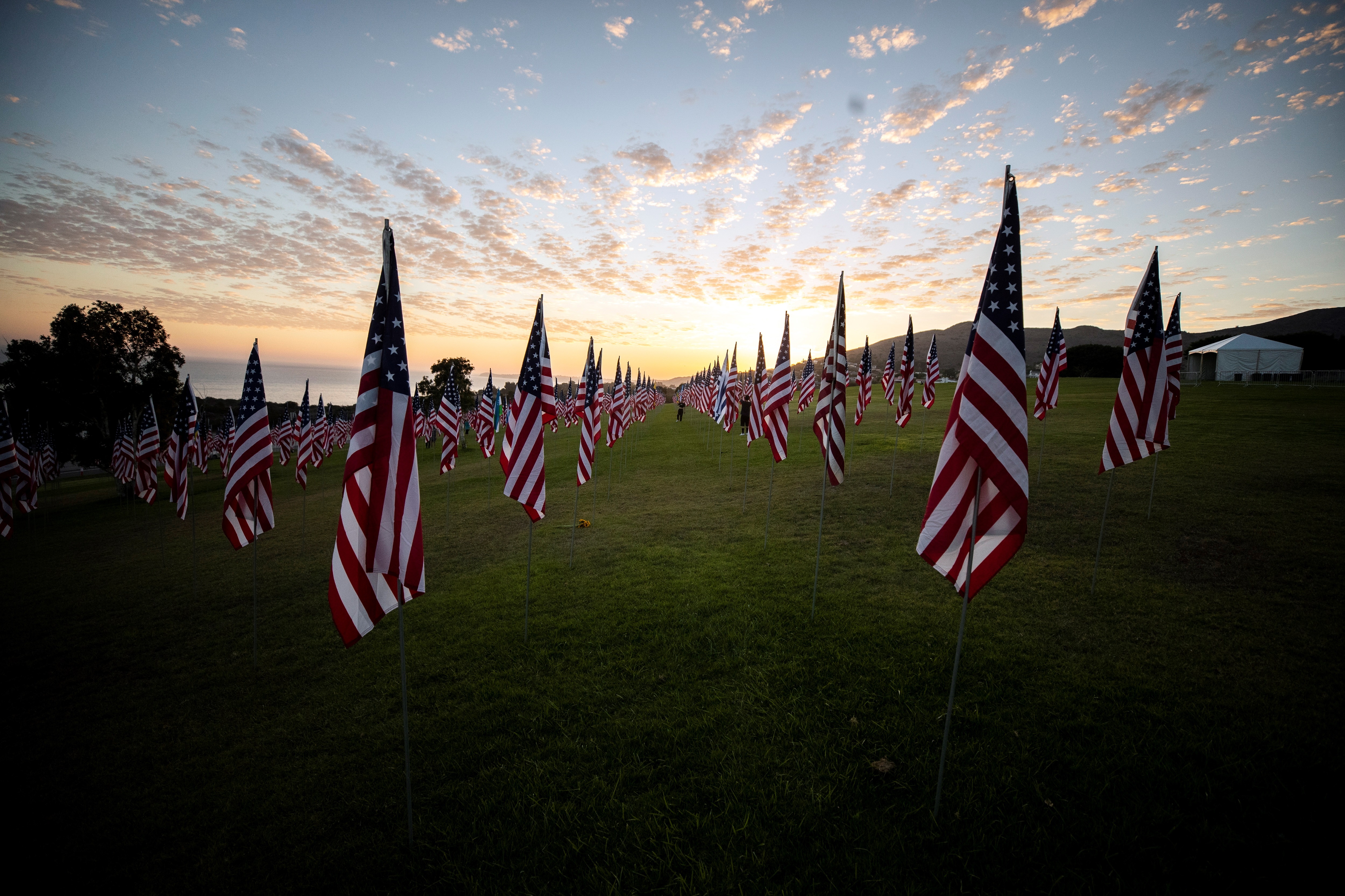 -FOTODELDIA- Malibu (Estados Unidos), 11/09/2021. - Un visitante camina entre las banderas de la instalación conmemorativa 'Olas de banderas' en la víspera del 20 aniversario del 11S, en la Universidad Pepperdine en Malibú, California, EE.UU.. La exhibición 'Olas de banderas' comprende 2977 banderas estadounidenses y extranjeras, honrando las vidas perdidas en los ataques terroristas en Nueva York, Pennsylvania y Washington, D.C. EFE/ETIENNE LAURENT