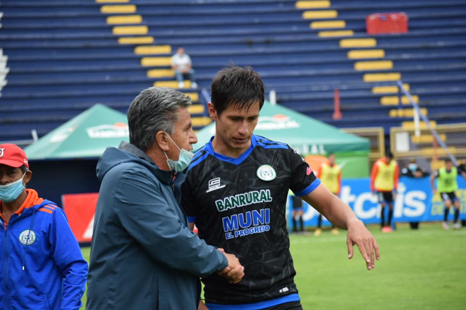 El mexicano Omar López llega al banquillo de su compatriota Raúl Arias después de anotar el gol que abrió el marcador en el estadio Mario Camposeco. Al final Achuapa se dejó empatar en el minuto 90+2. Foto Deportivo Achuapa. 
