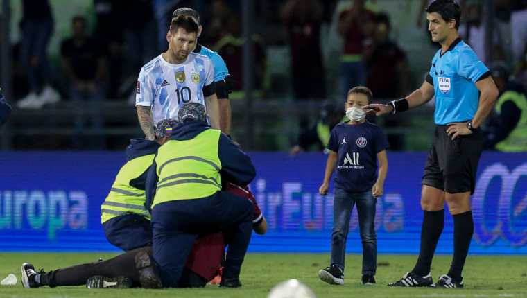 Un niño venezolano burló a la seguridad del estadio y logró llegar a Leo Messi para darle un abrazo. El delantero del PSG le devolvió el gesto. Mientras que otro aficionado no tuvo la misma suerte. En la foto lo detiene la seguridad del Estadio Olímpico de Caracas. Foto Prensa Libre: AFP.