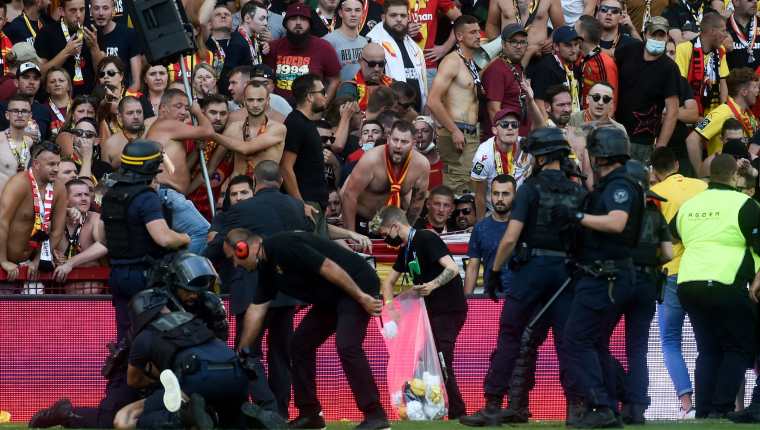 La policía arresta a un hombre luego de que los fans del Lens invadieran la cancha  del Stade Bollaert-Delelis. (Foto Prensa Libre: AFP)