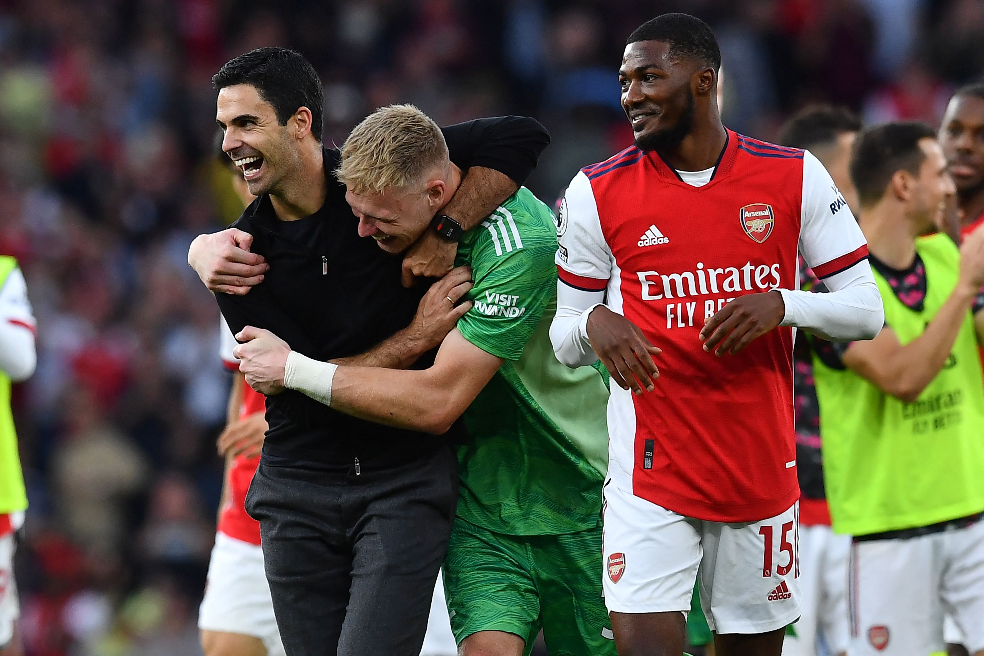 El entrenador del Arsenal, Mikel Arteta (izquierda) y su portero, Aaron Ramsdale (verde) festejan después de pegarle al Tottenham Hotspur. (Foto Prensa Libre: AFP)
