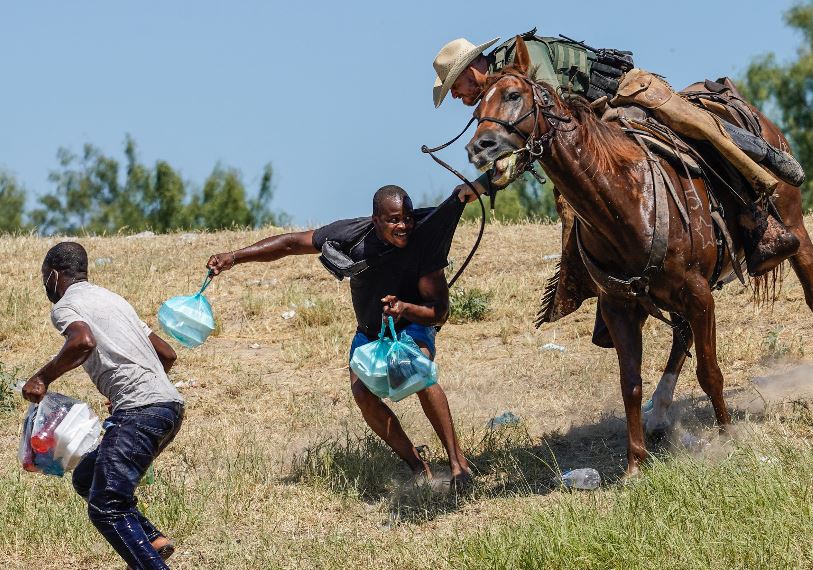 Un agente de la Patrulla Fronteriza a caballo tratar de evitar que un migrante haitiano ingrese a un campamento a orillas del Río Grande, cerca del Puente Internacional Acuña del Río en Del Río, Texas. (Foto Prensa Libre: AFP)