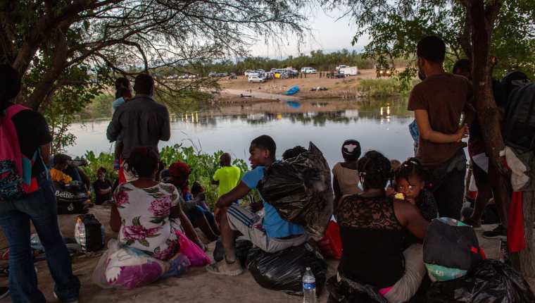 Migrantes haitianos esperan para cruzar el Río Grande en Del Rio, Texas.  (Foto Prensa Libre: AFP)