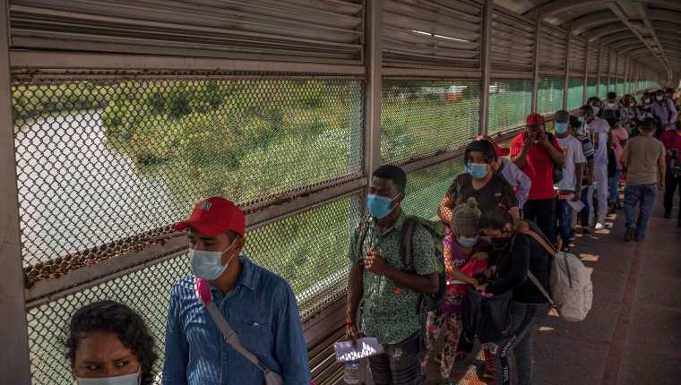 Personas que migran, en su mayoría desde Centroamérica y Haití, esperan en el Puente Internacional en Matamoros, México, para ingresar a Estados Unidos para solicitar asilo en agosto de este año. (Foto Prensa Libre: Daniele Volpe/New York Times)