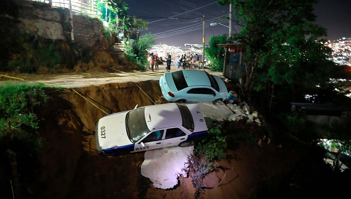 ACAPULCO (MÉXICO), 08/09/2021.- Dos coches a punto de caer a un barranco por el suelo reblandecido, debido al sismo de 7.1, en el balneario de Acapulco, en el estado de Guerrero (México). El gobernador del sureño estado de Guerrero, Héctor Astudillo, informó de que una persona falleció por la caída de un poste de la luz en el municipio de Coyuca de Benítez tras el terremoto que sacudió el centro y sur de México. EFE/David Guzmán
