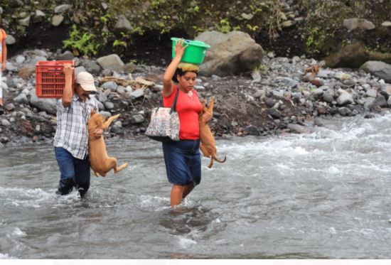 Pobladores cruzan a pie el río Mineral debido a que no se puede cruzar en vehículo. (Foto Prensa Libre: Byron García) 