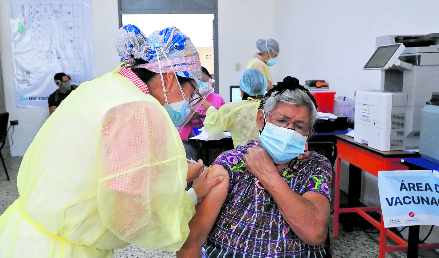 Mujer recibe vacuna contra el coronavirus en la Universidad de San Carlos de Guatemala. (Foto Prensa Libre: Elmer Vargas)